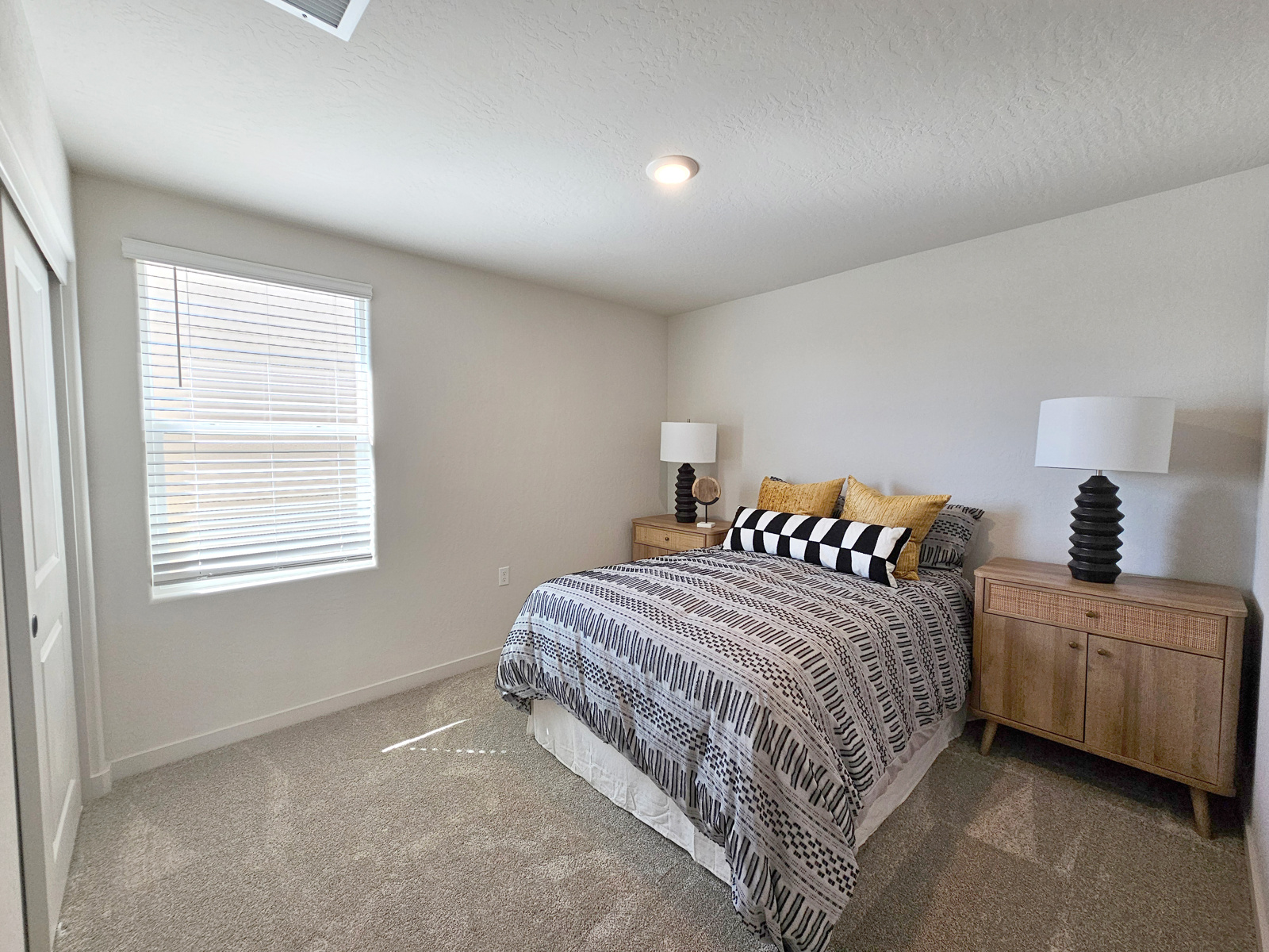 A bedroom with a bed and lamps.