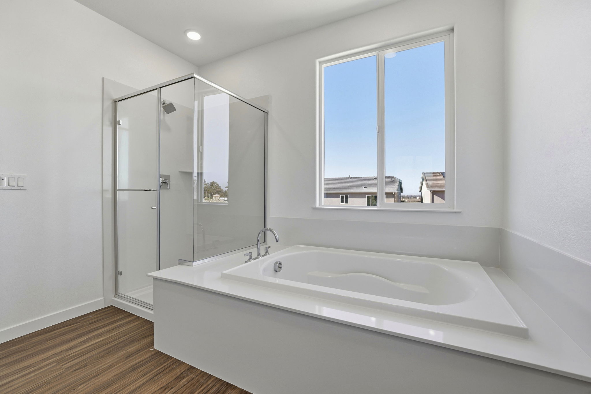 A bathroom with a large tub and a large window.