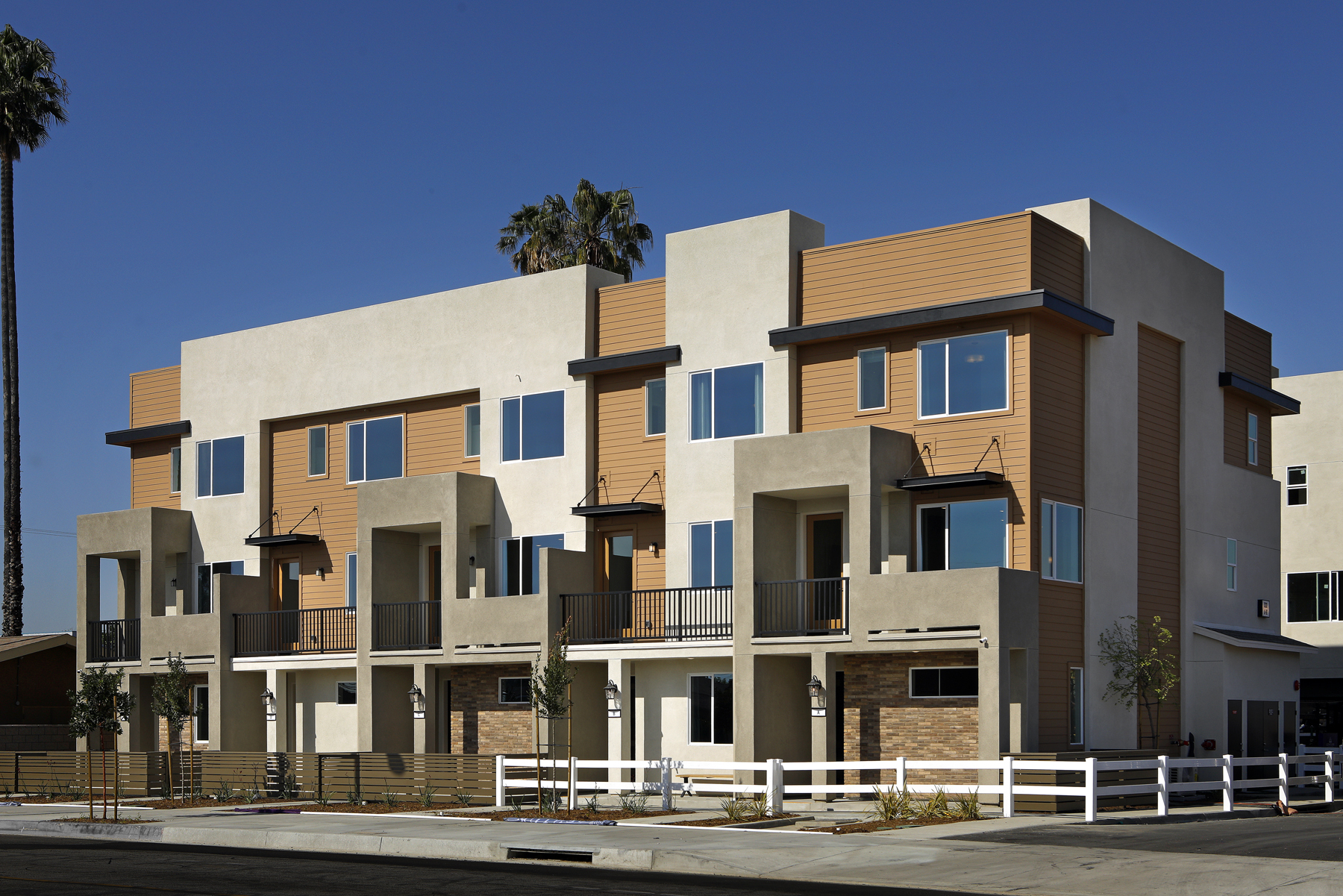 A large building with a white fence.