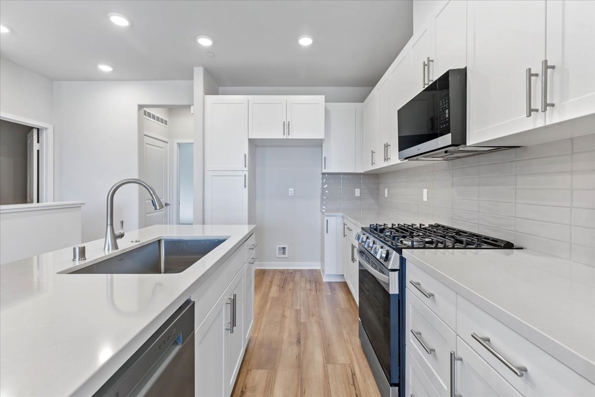 A kitchen with white cabinets.