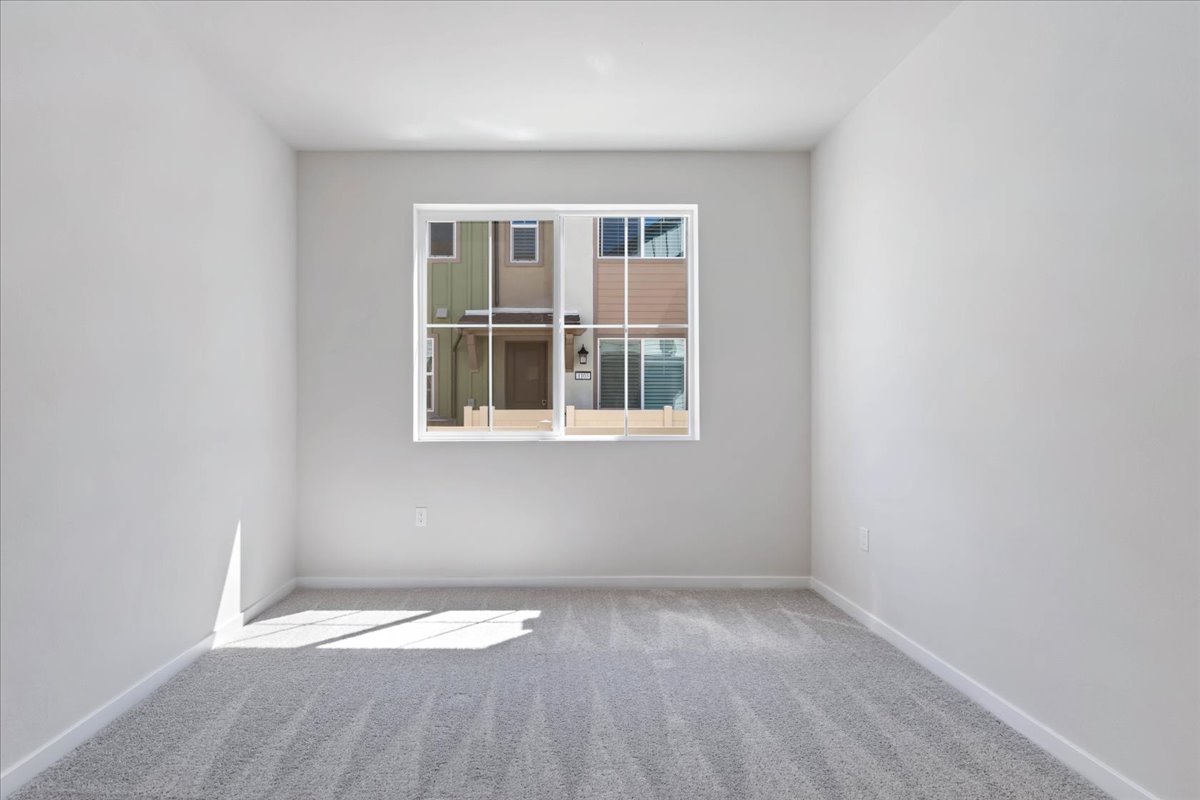 A room with a window and a rug.