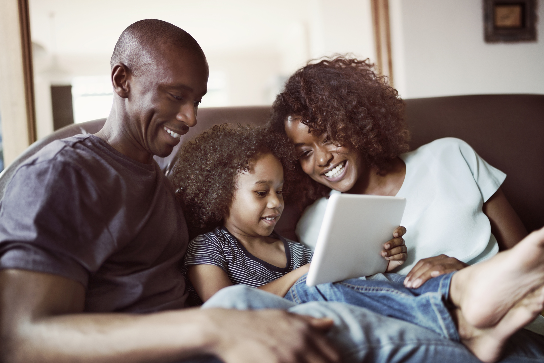 A family sitting on a couch.
