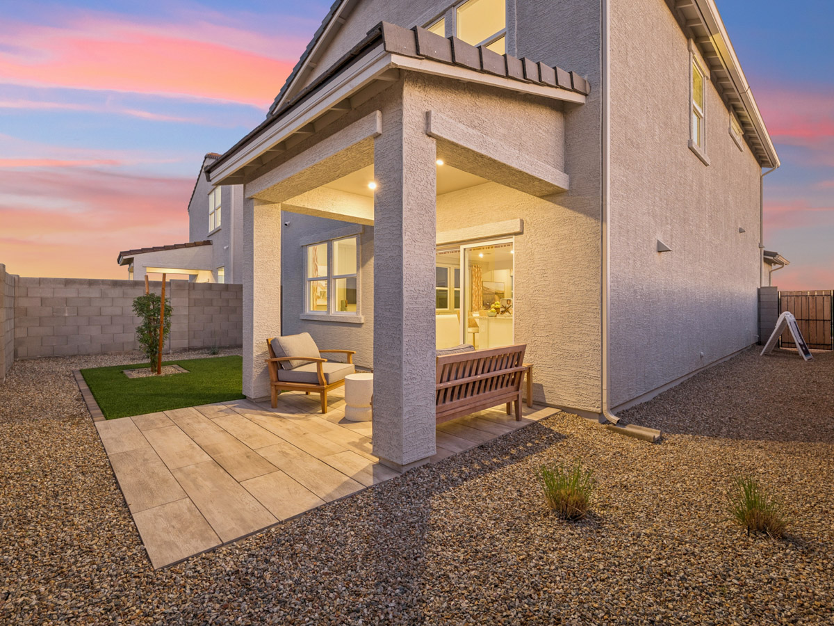 A house with a patio and a bench in the front.