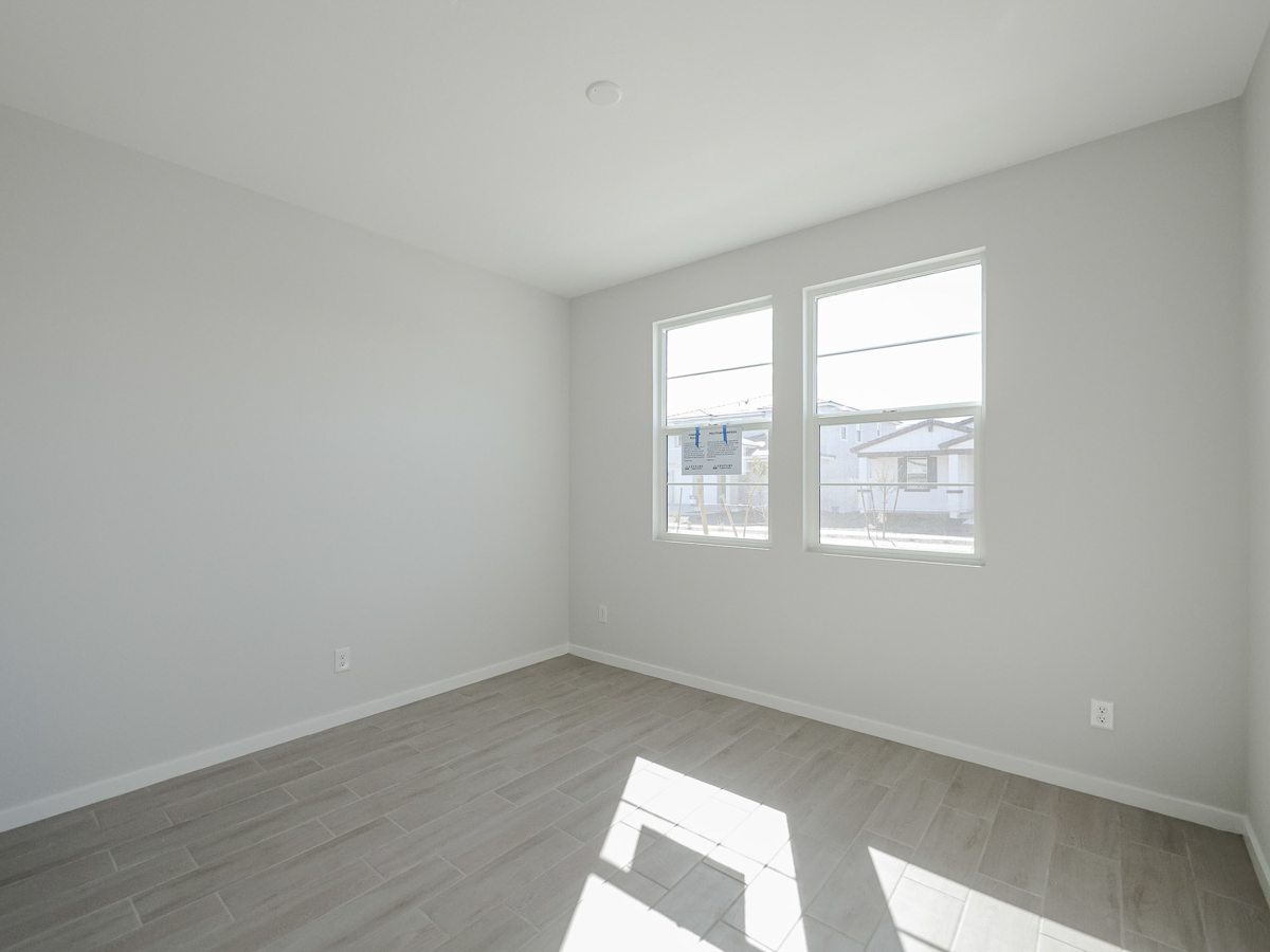 A room with a window and a wood floor.