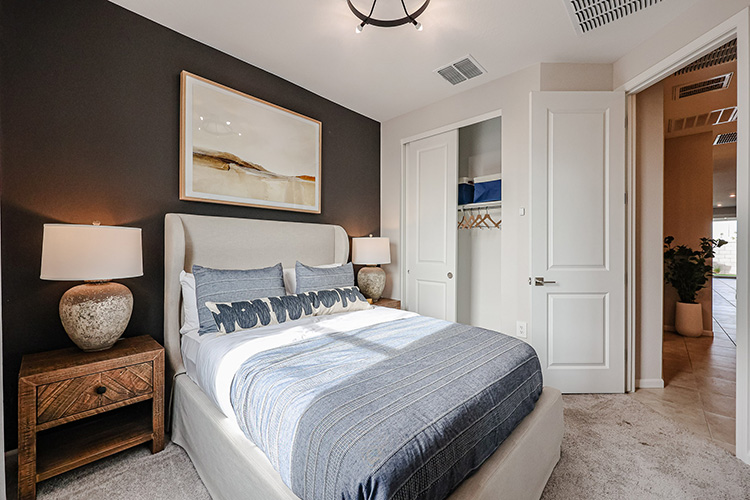 A bedroom with a bed and a mirror.