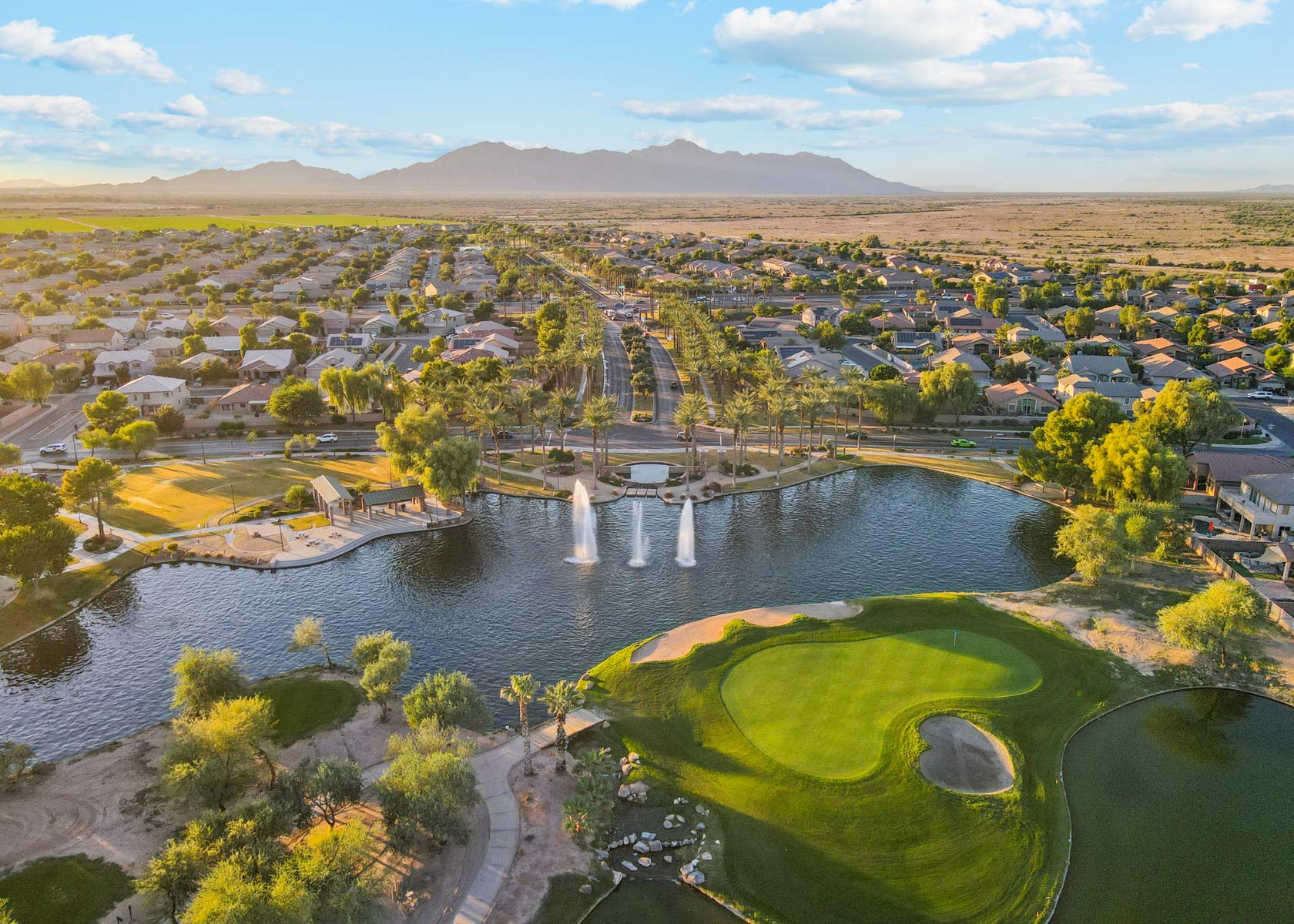 A river with a waterfall and a town in the background.