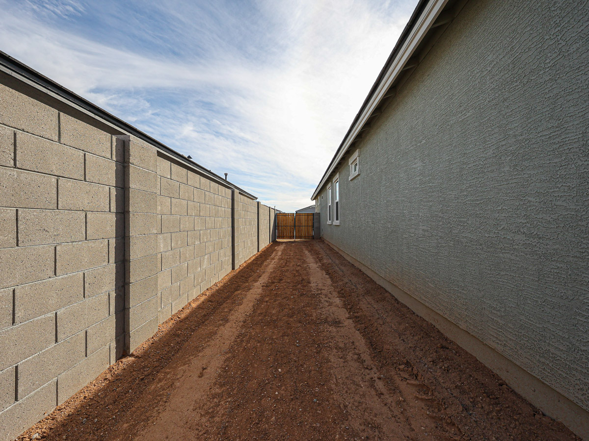 A dirt road between two brick walls.