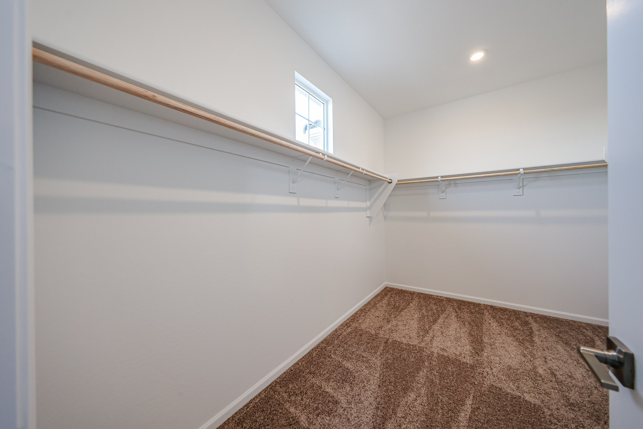 A room with a window and a rug.