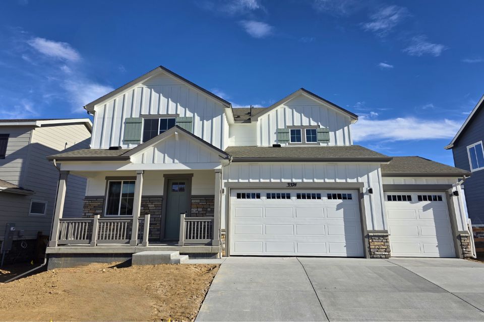 A white house with garages.