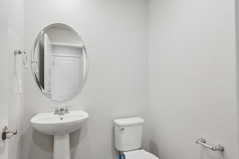 A bathroom with a round mirror.