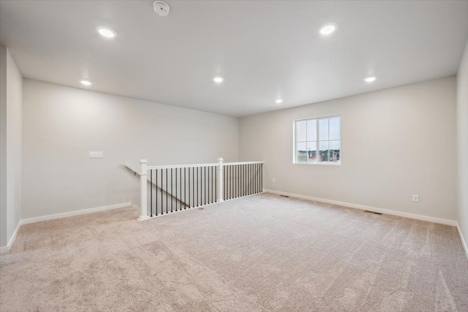 A room with a white carpet and a window.