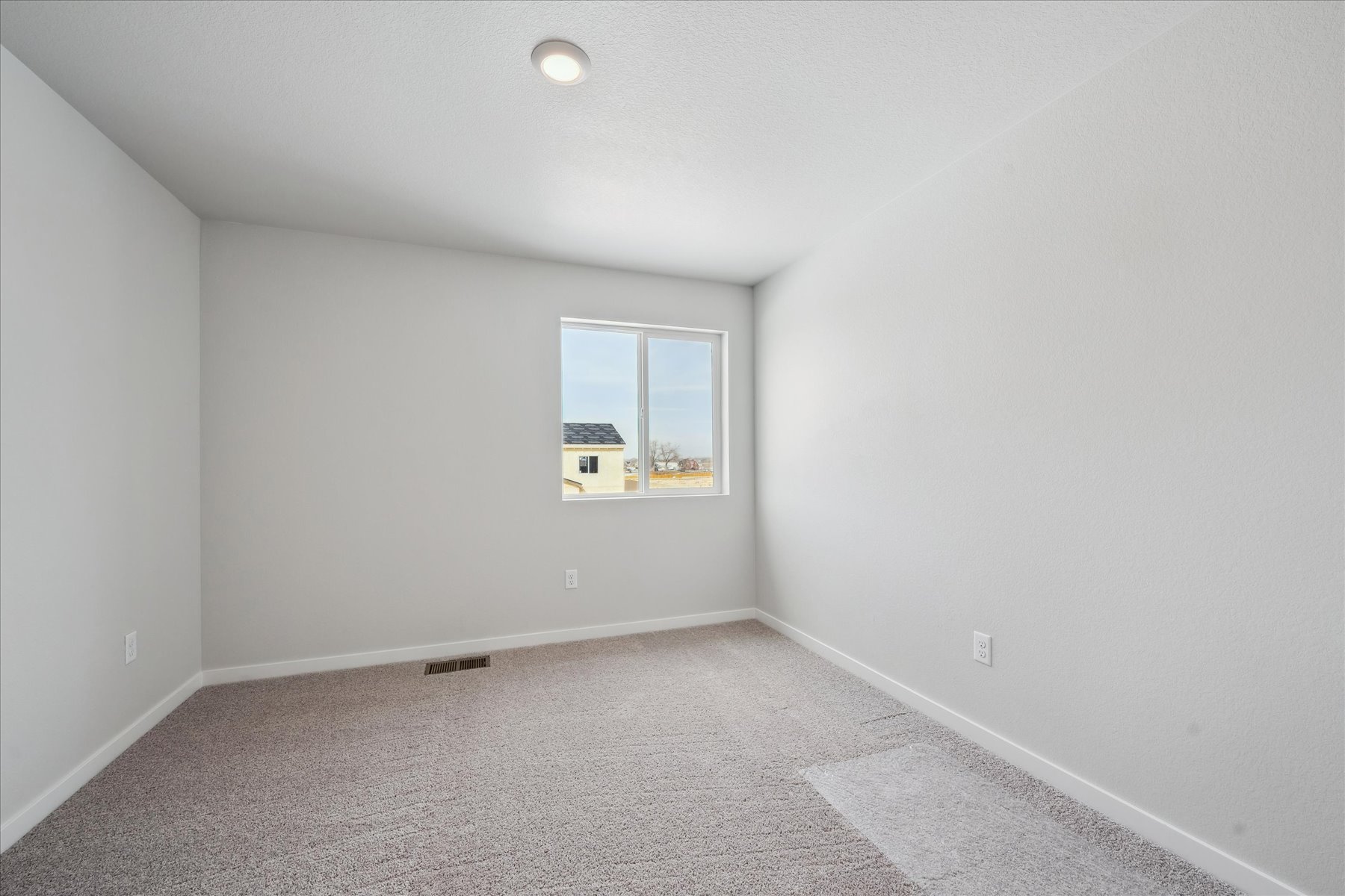 A room with a window and a carpet.