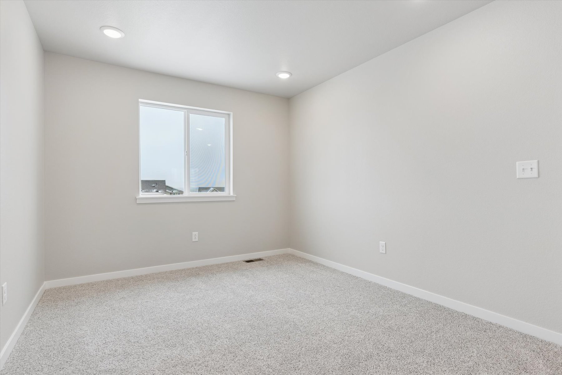 A room with a window and a carpet.