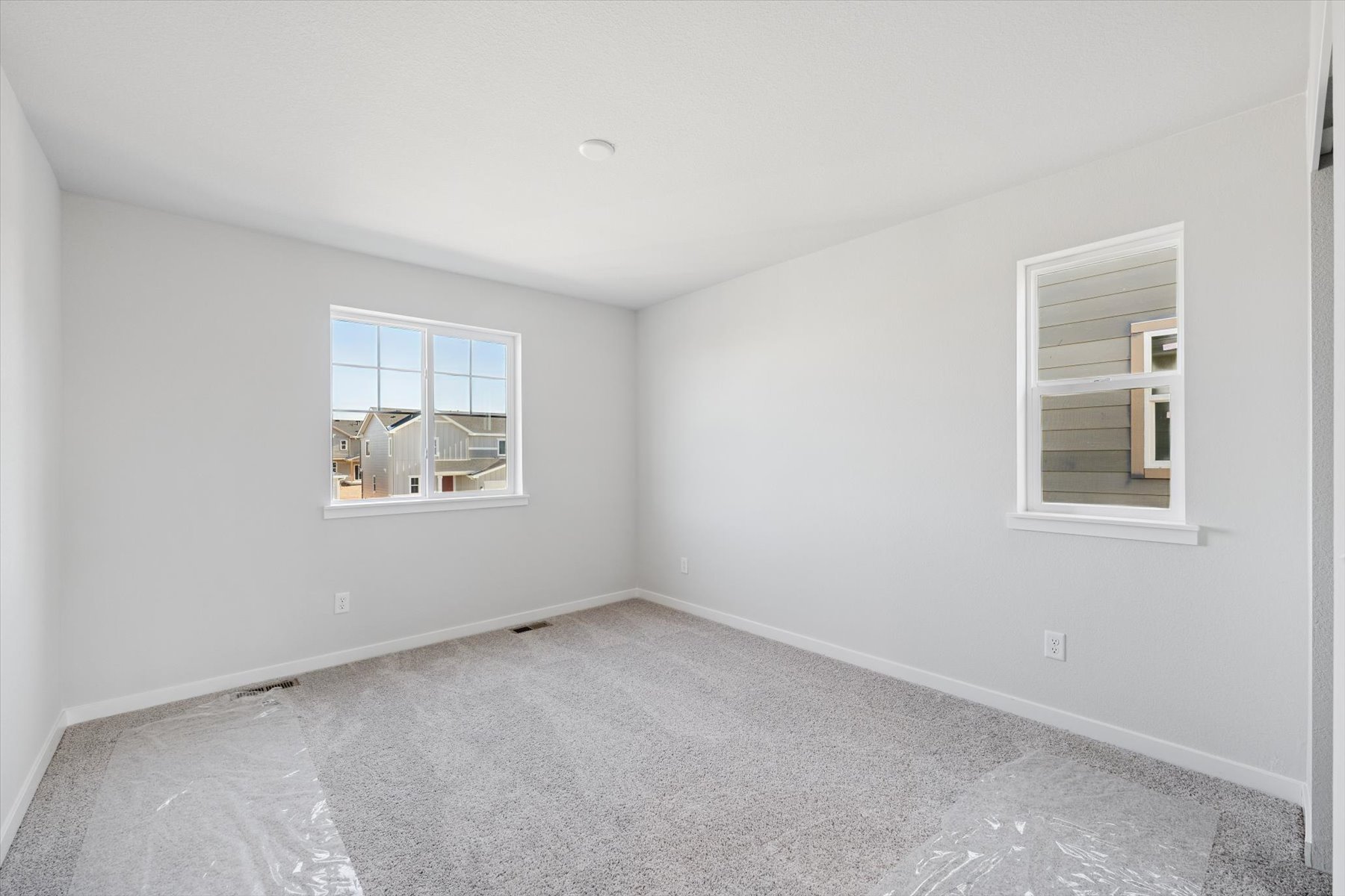 A room with a carpet and windows.