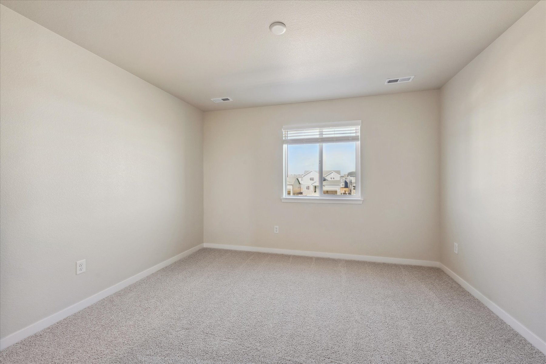 A room with a window and a carpet.