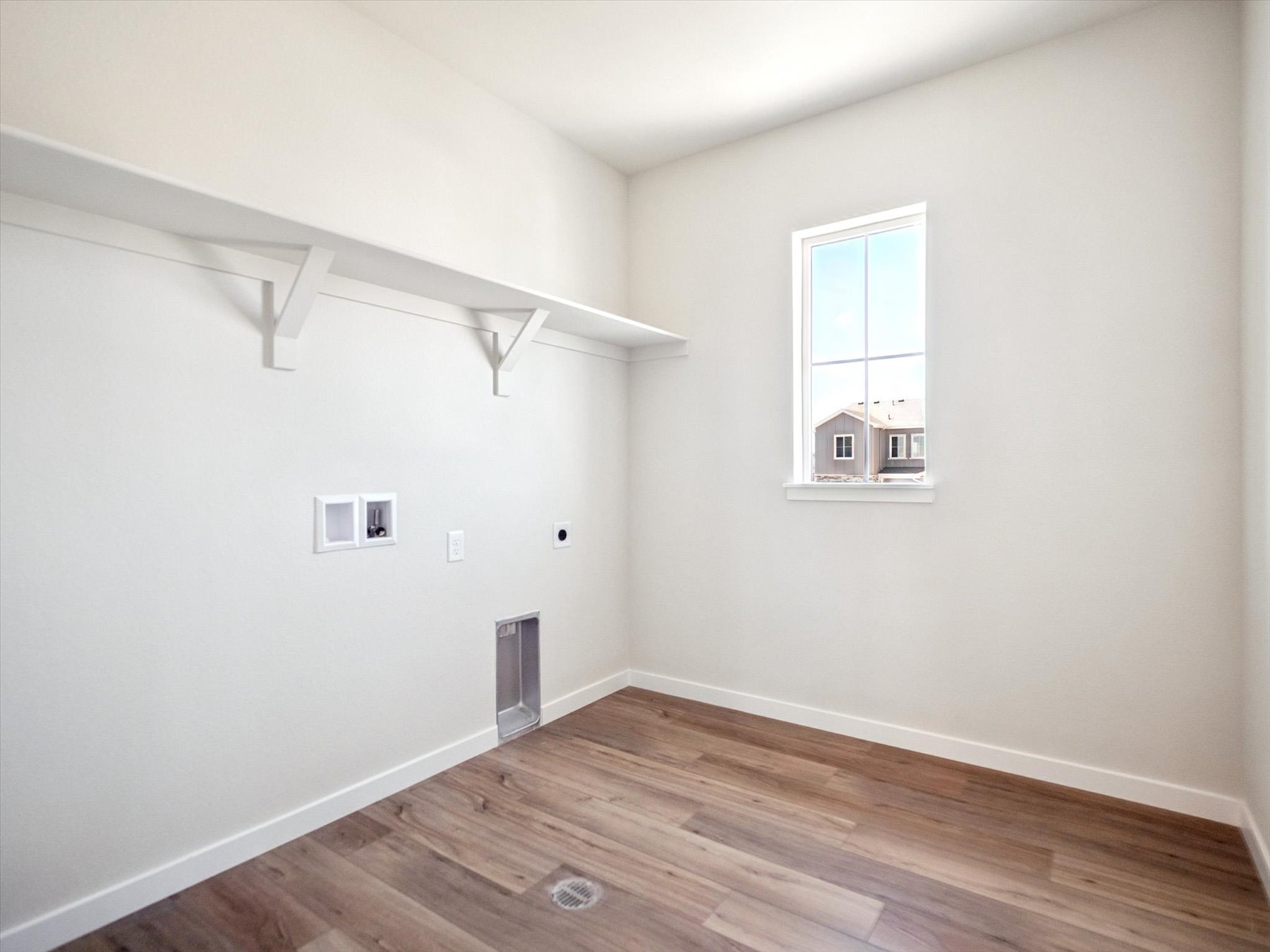 A room with a wood floor and a window.