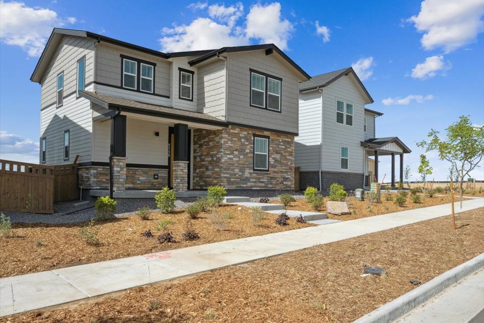 A house with a fence and a dirt road.