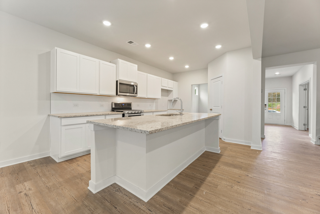 A kitchen with white cabinets.