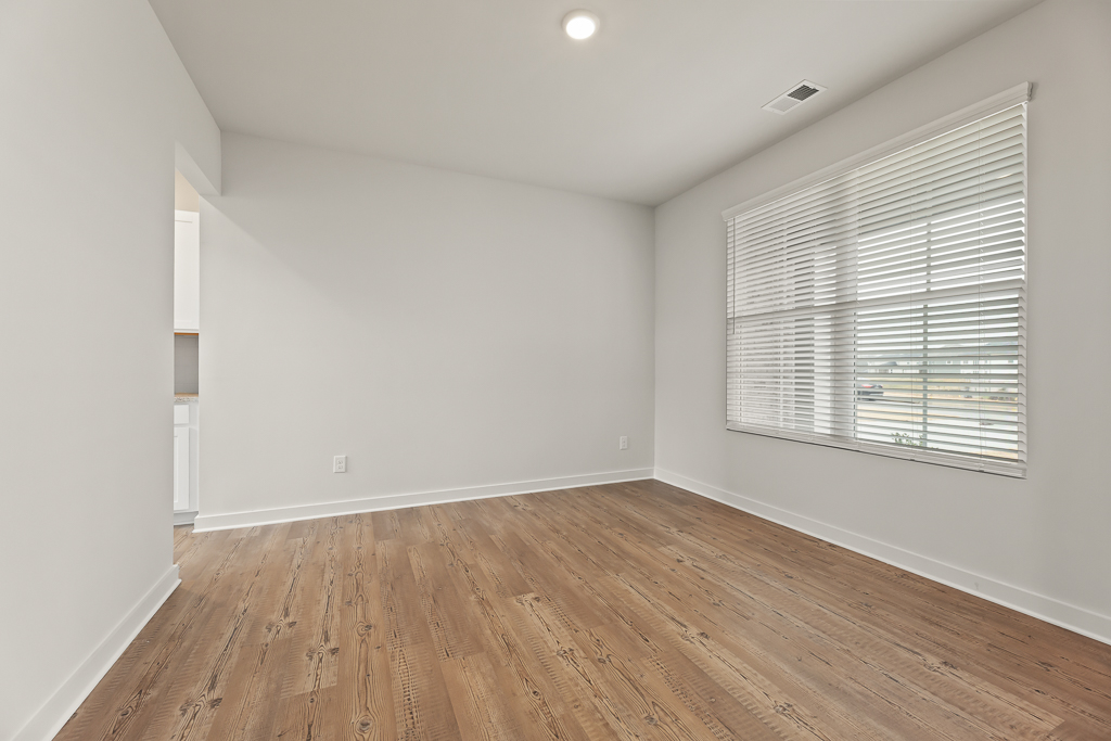 A room with a wood floor and a window.