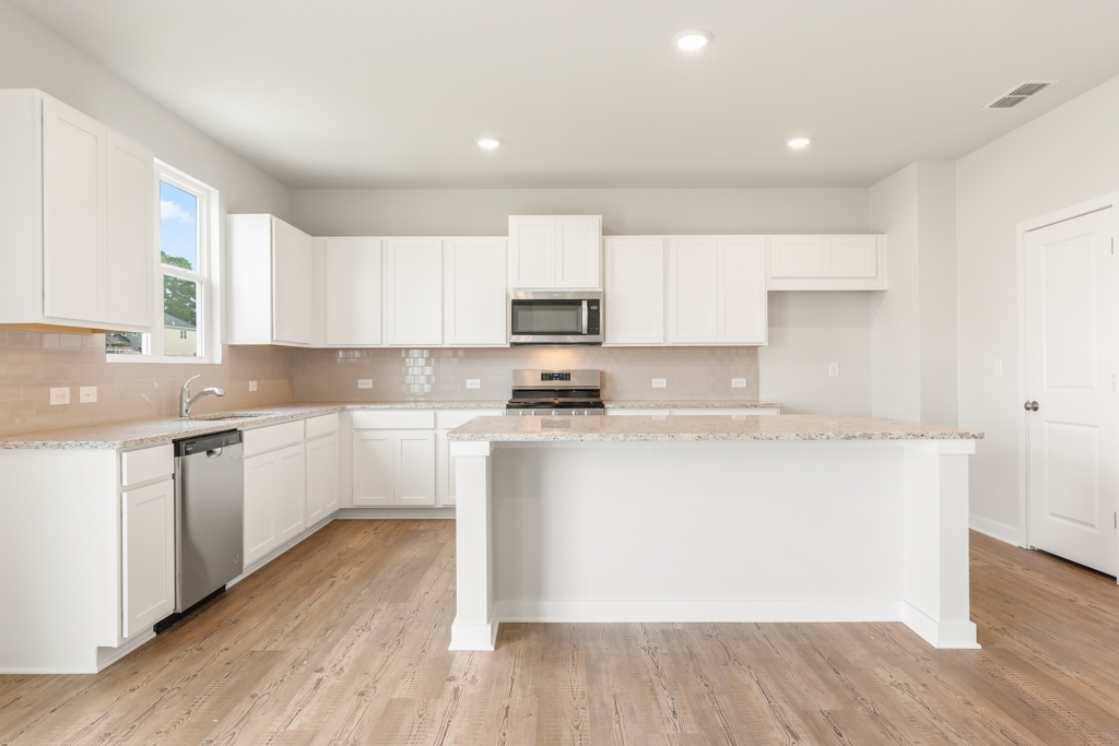 A kitchen with white cabinets.