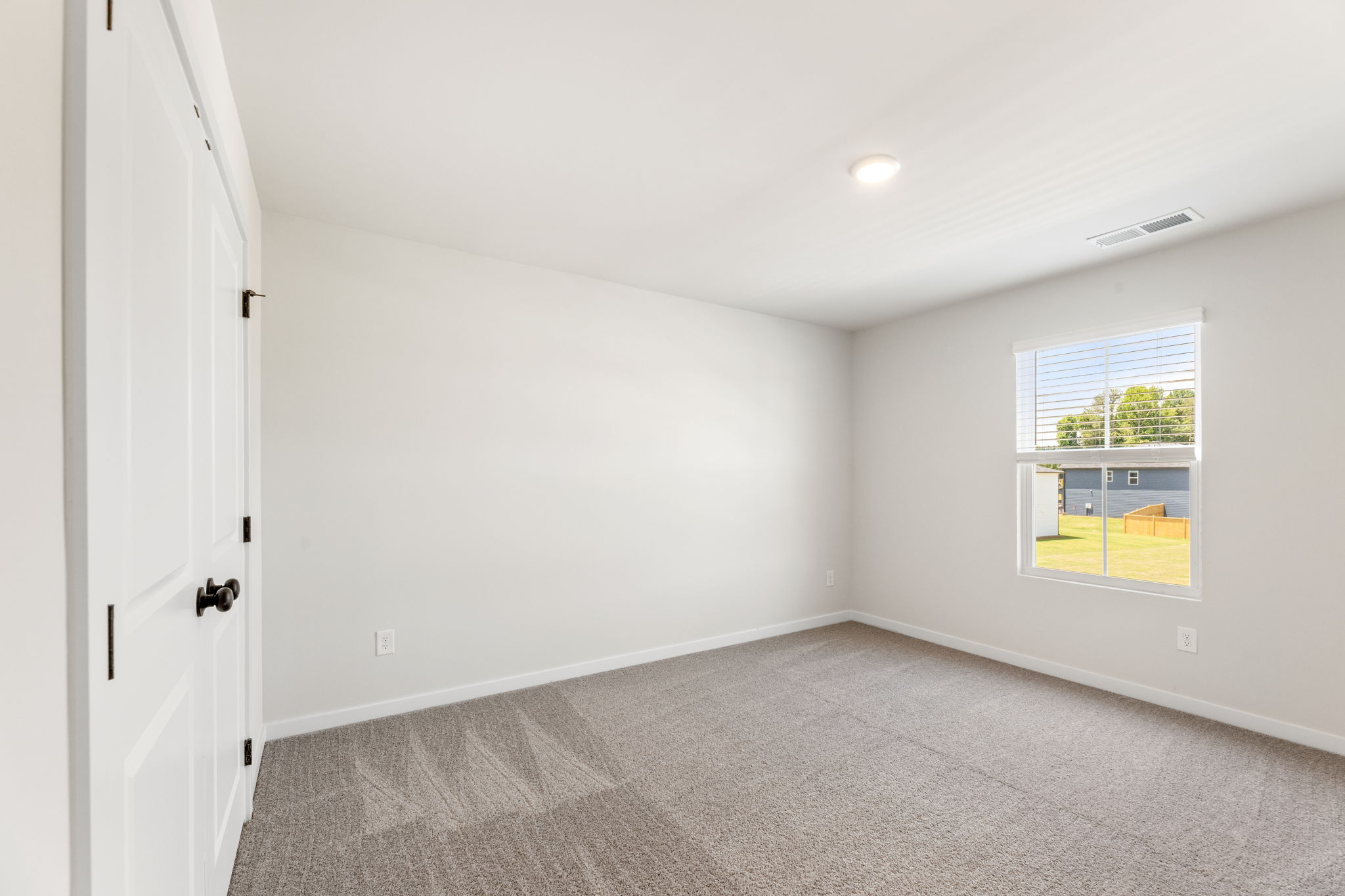 A room with a carpet and a window.
