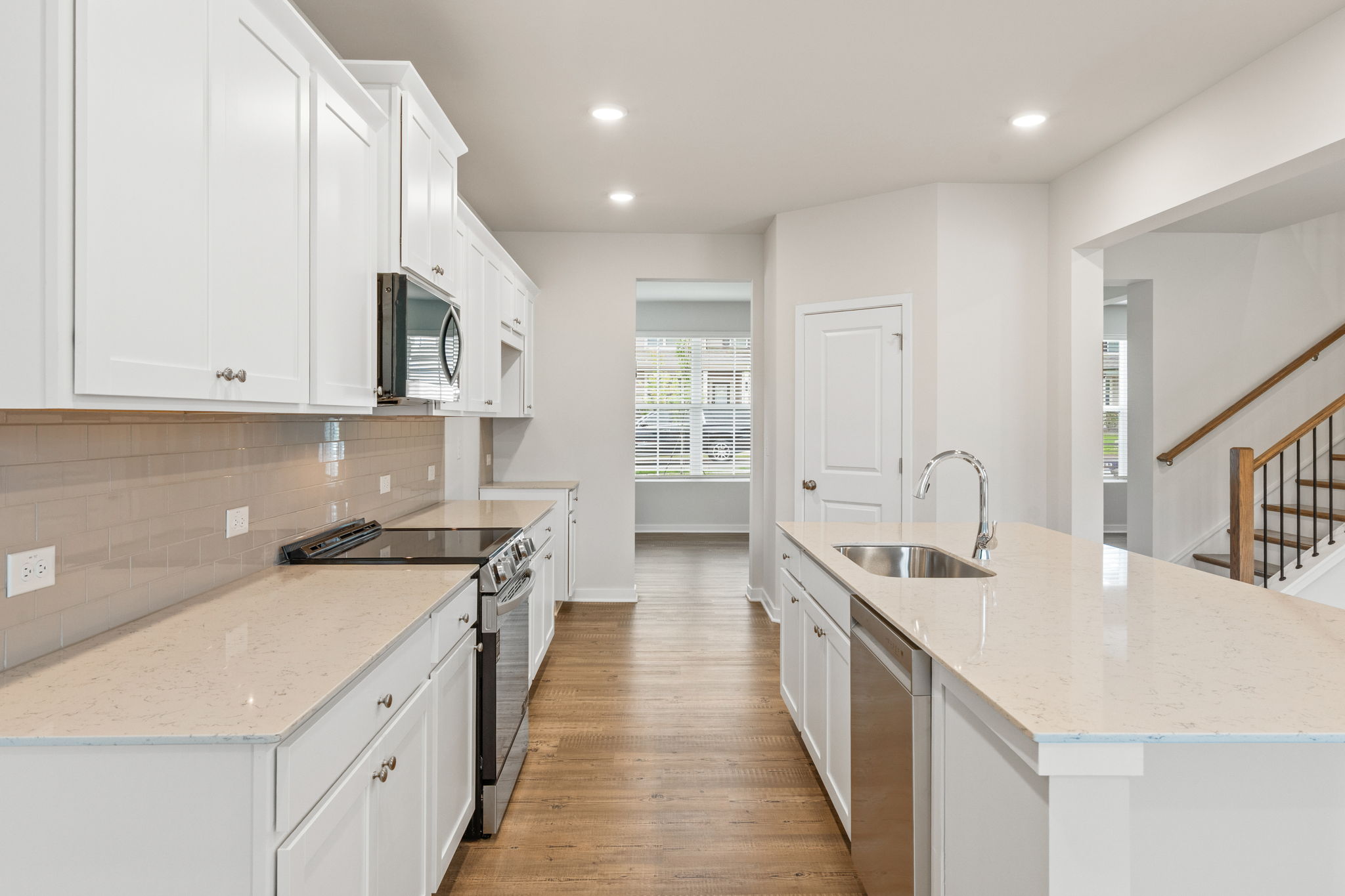 A kitchen with white cabinets.