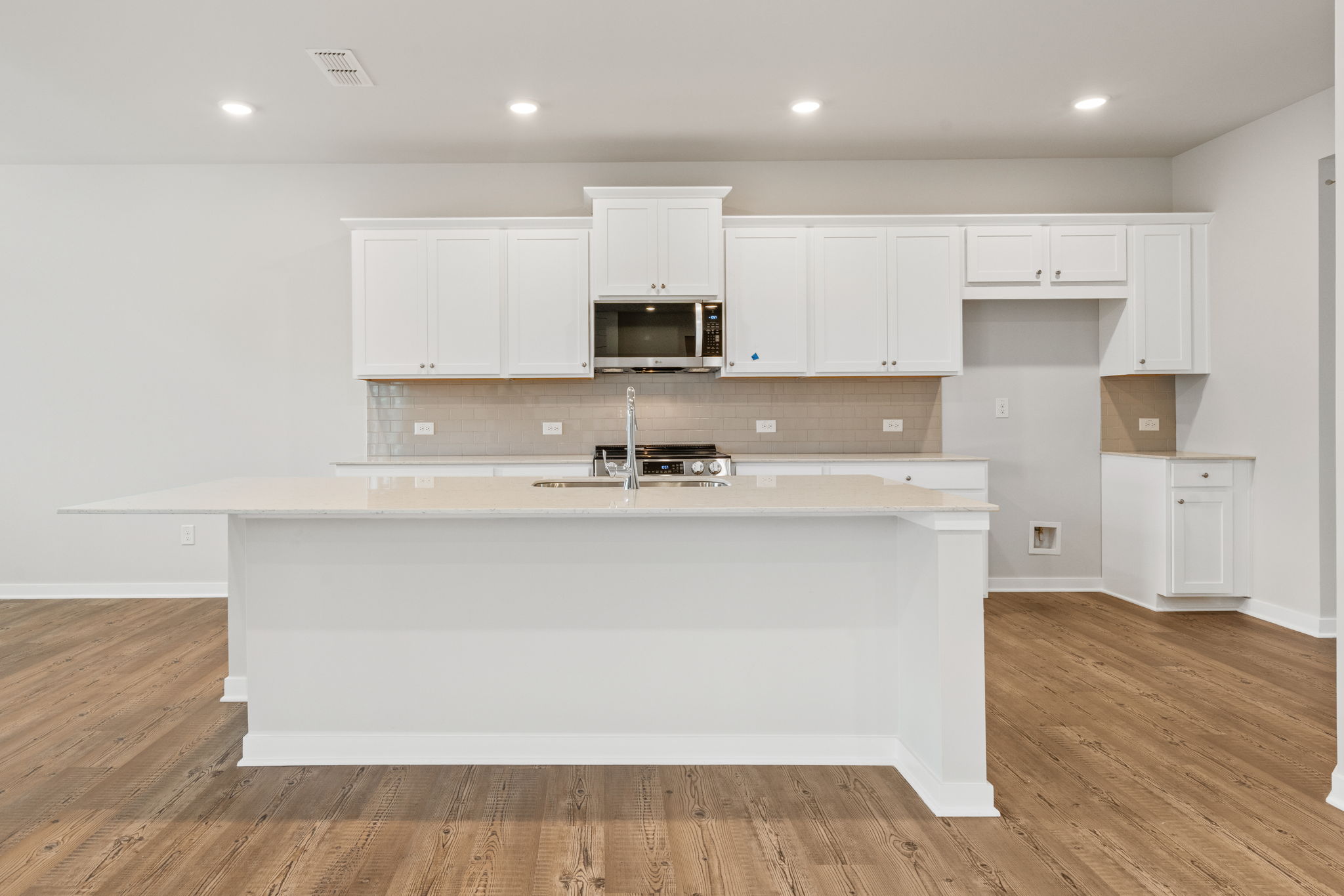 A kitchen with white cabinets.