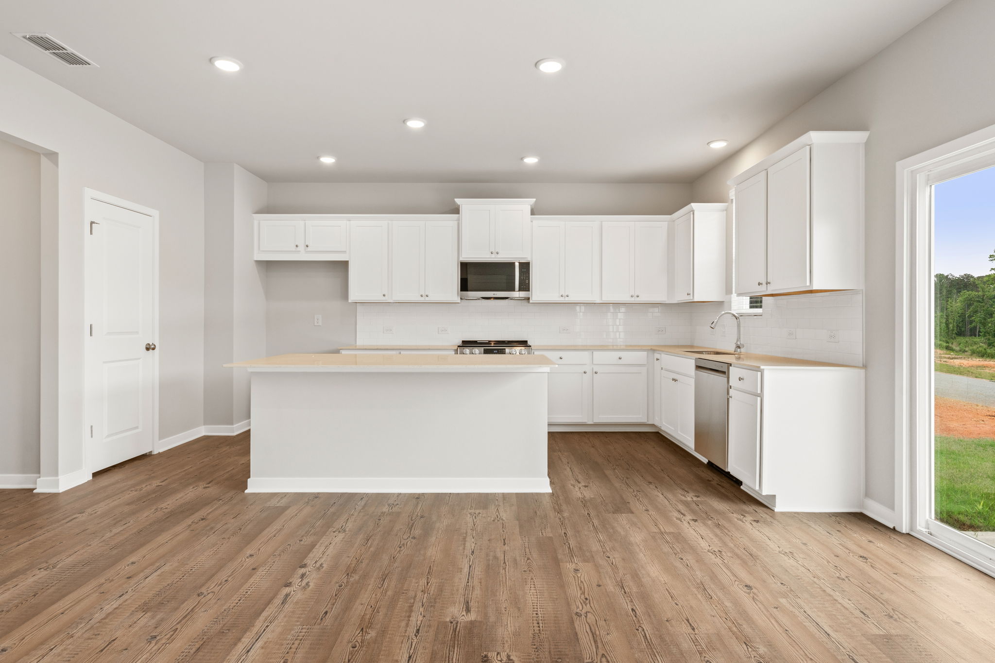 A kitchen with white cabinets.