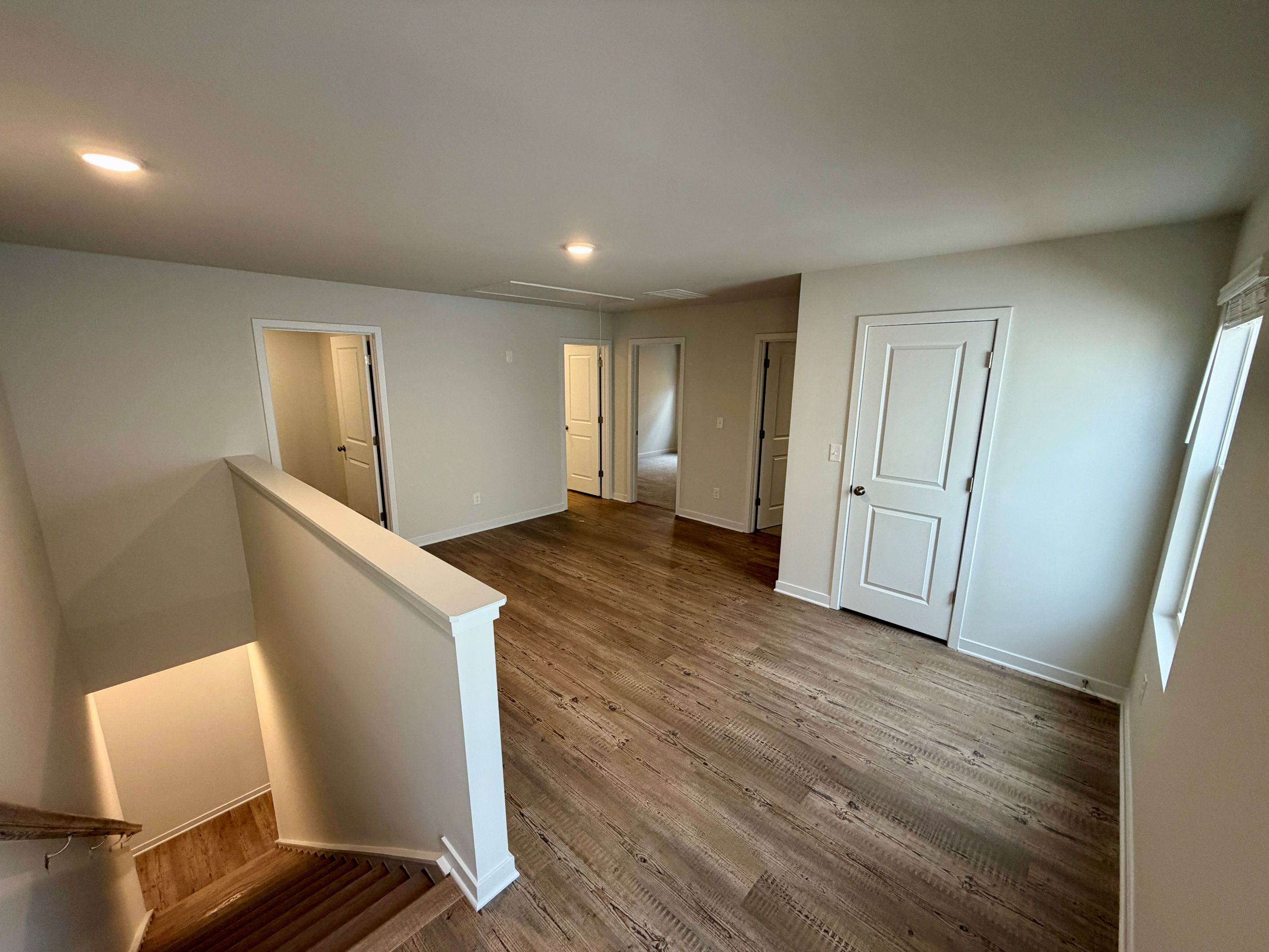 A room with white walls and wood floors.