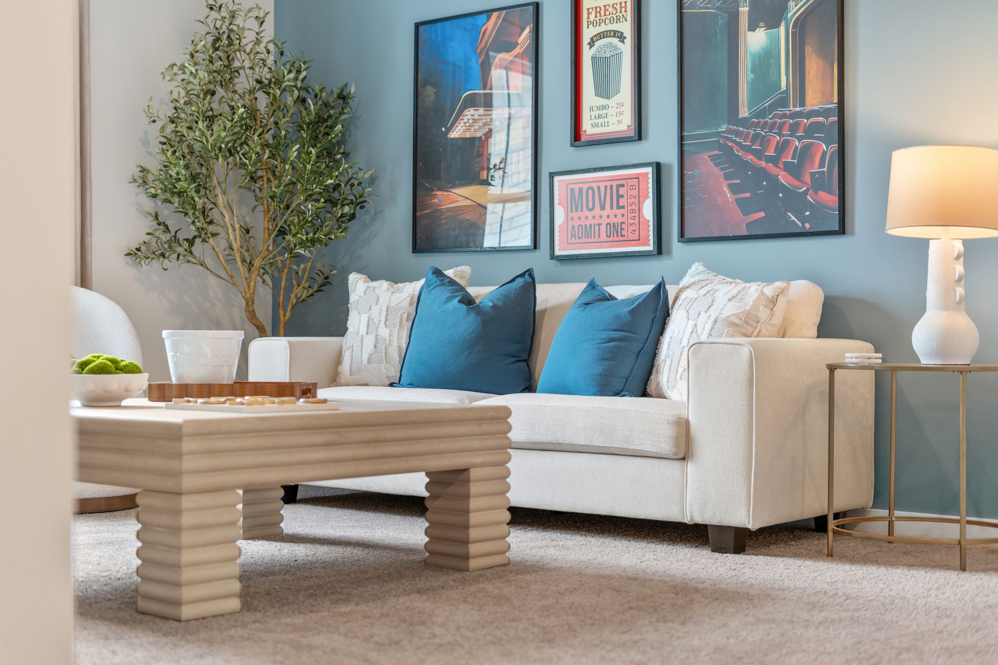 A white couch with blue pillows.
