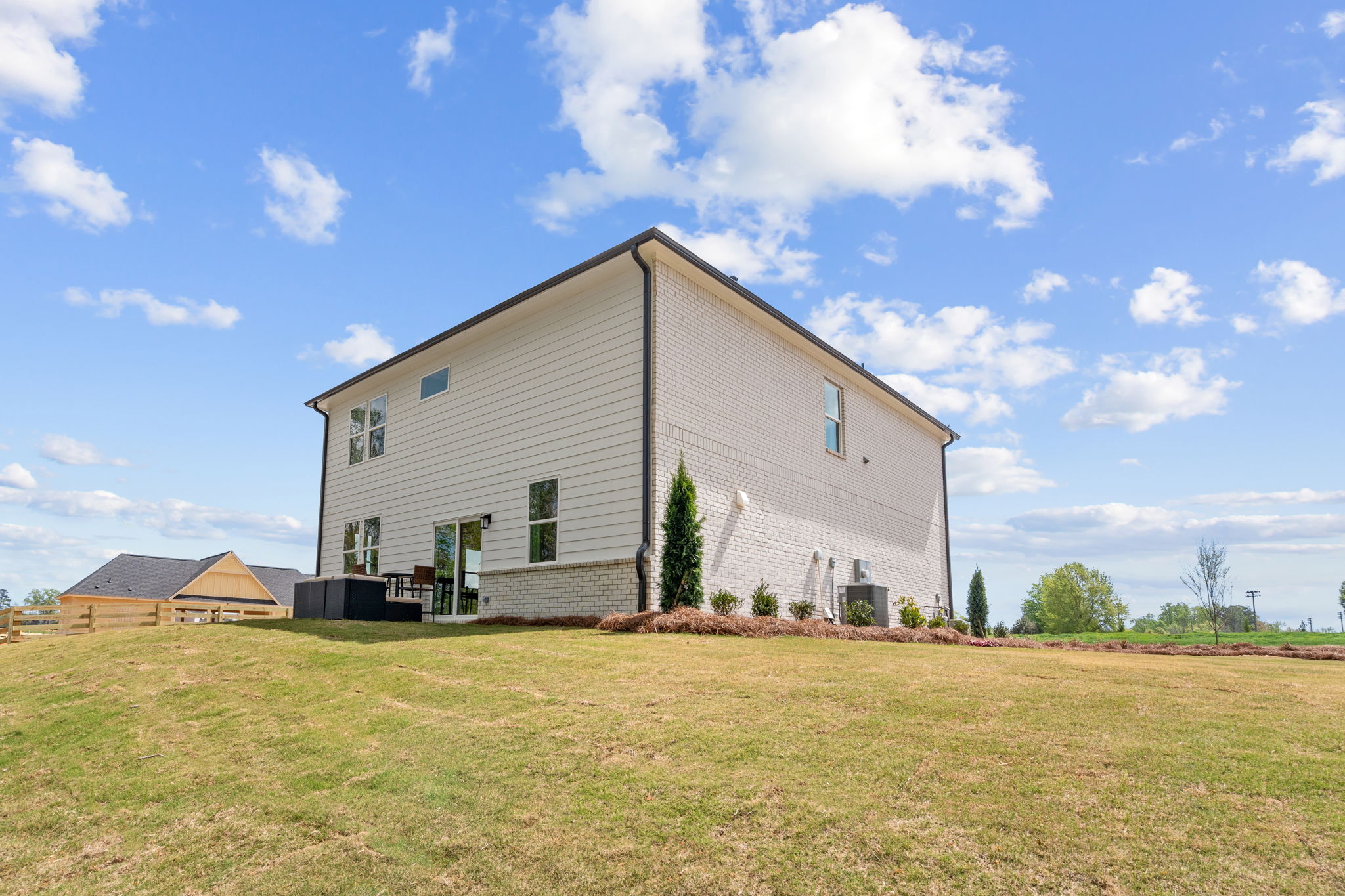 A house with a grass field with Rockingham Meeting House in the background.