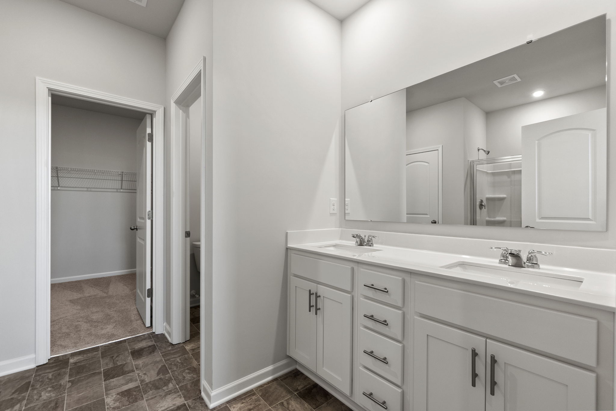 A bathroom with white cabinets.