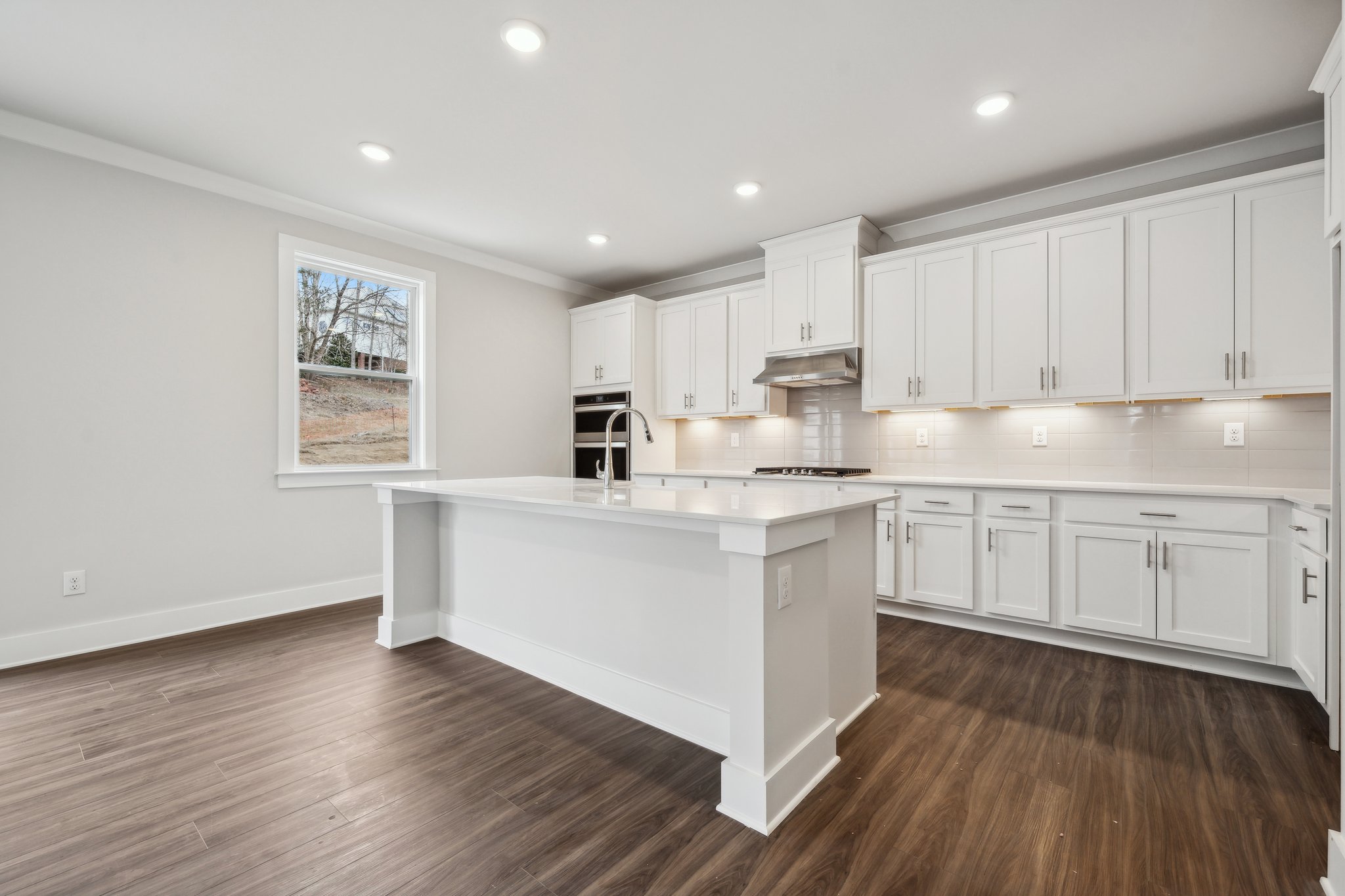 A kitchen with white cabinets.