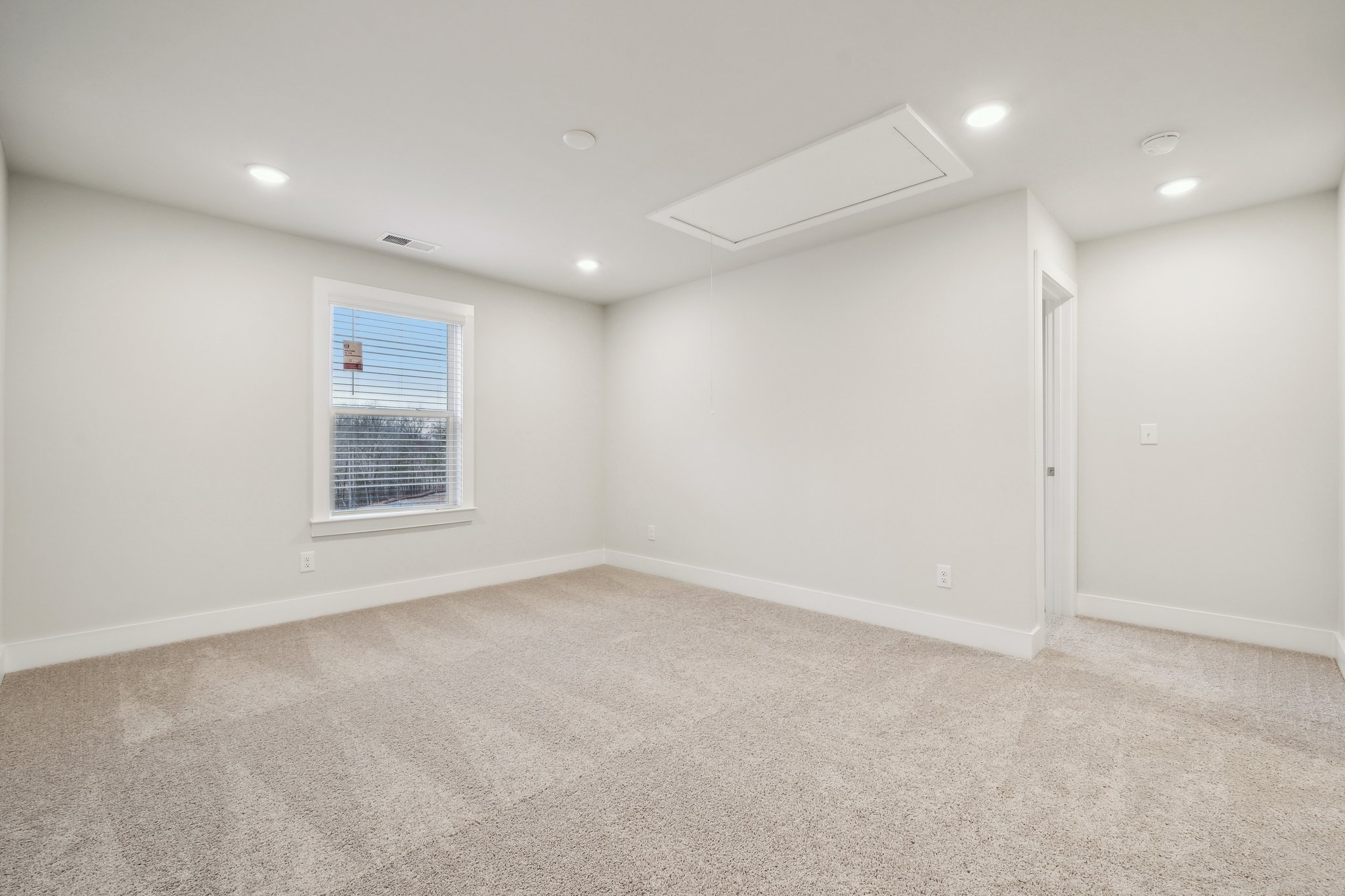 A room with a window and a carpet.