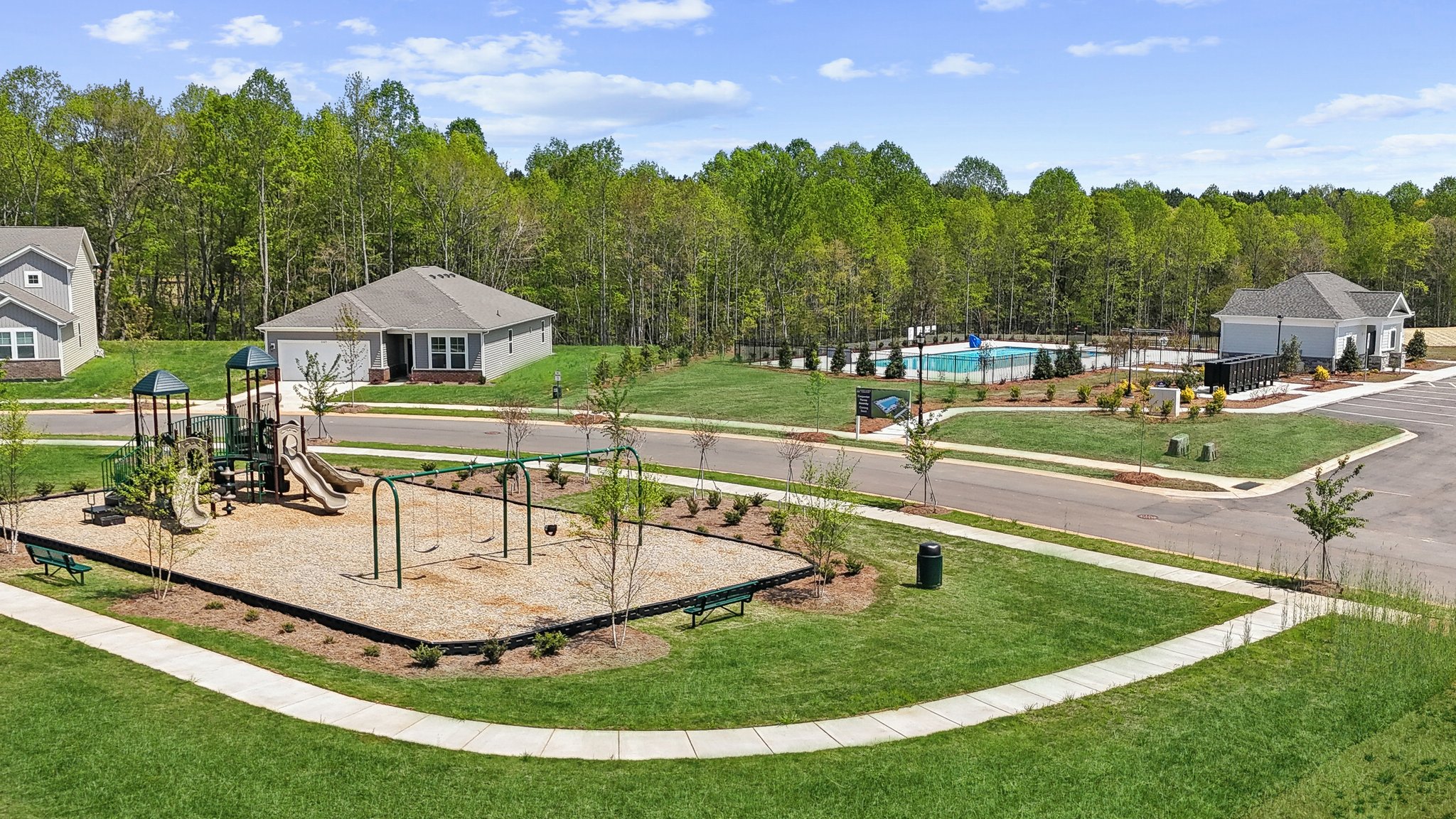 A backyard with a trampoline and trees in the background.
