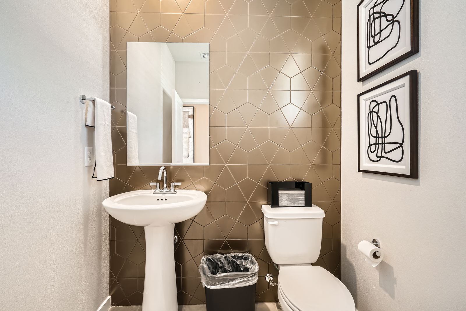 A bathroom with a sink toilet and a mirror.
