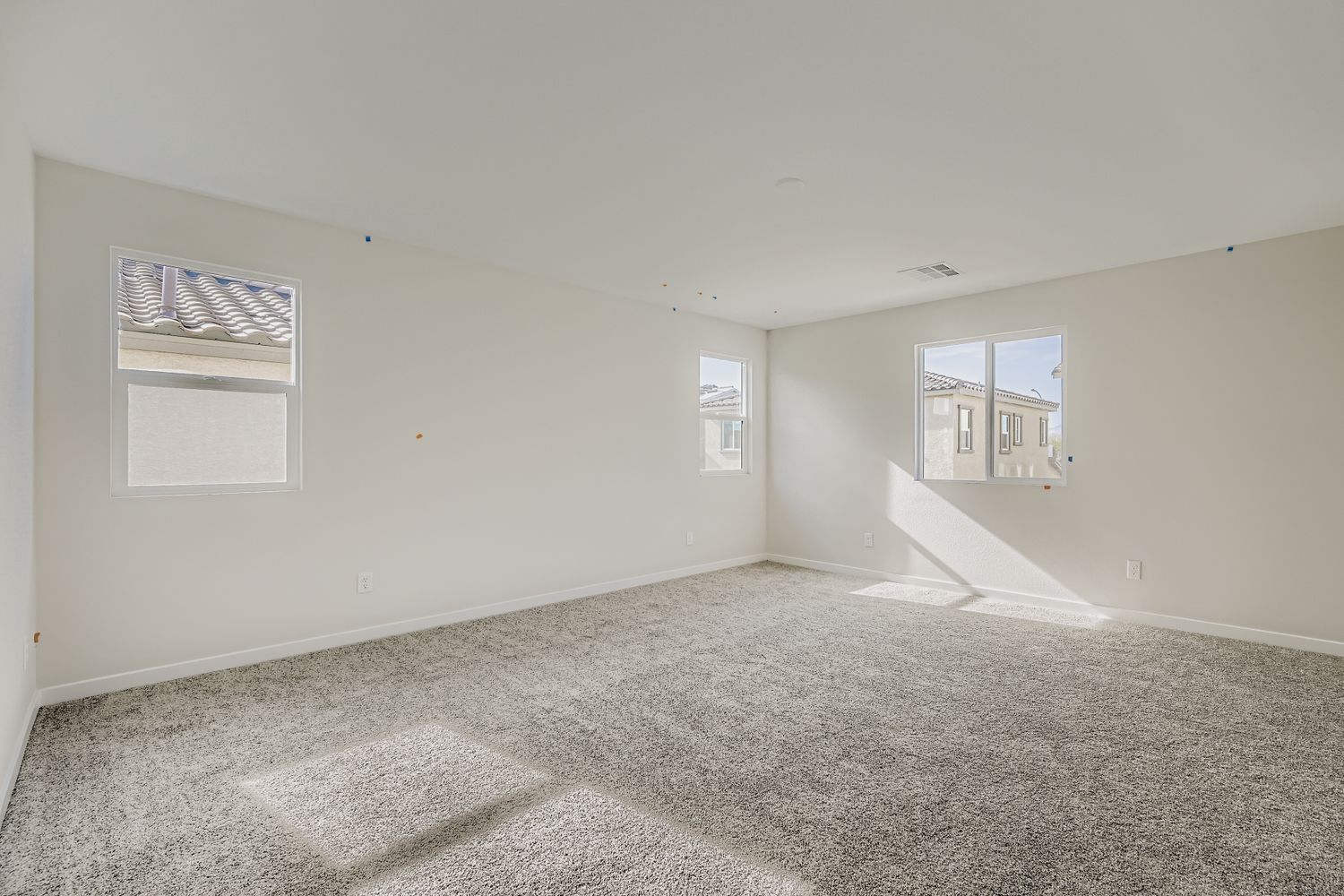 A room with a carpet and windows.