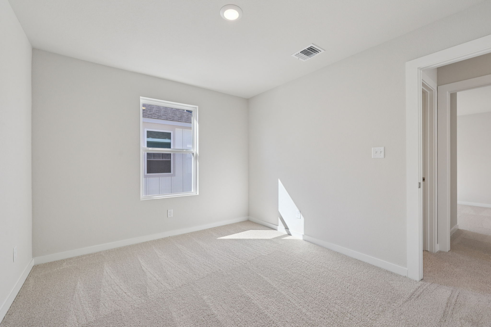A room with a window and a carpet.