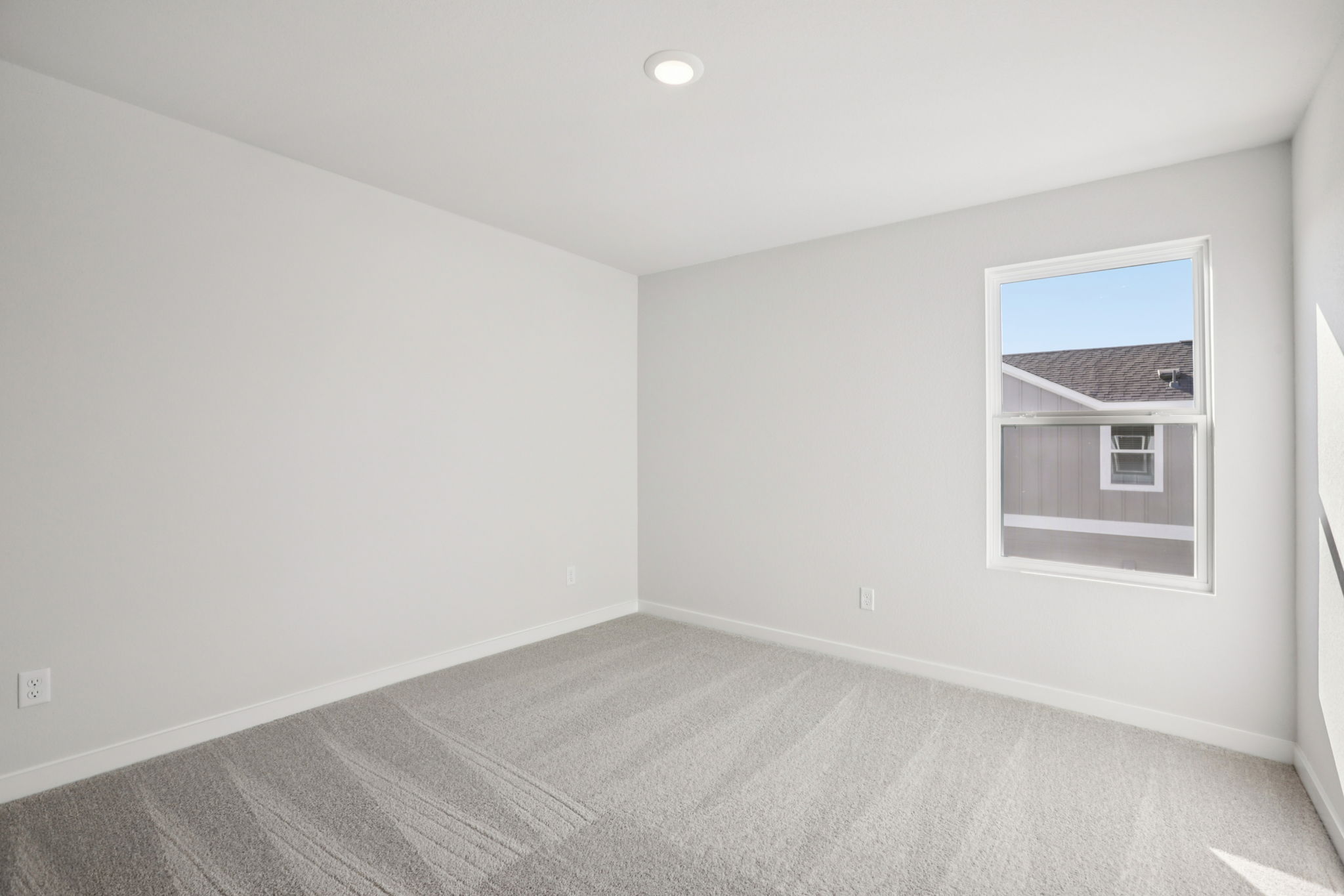 A room with a carpet and a window.