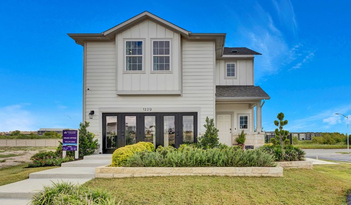A white house with a sign in front of it.