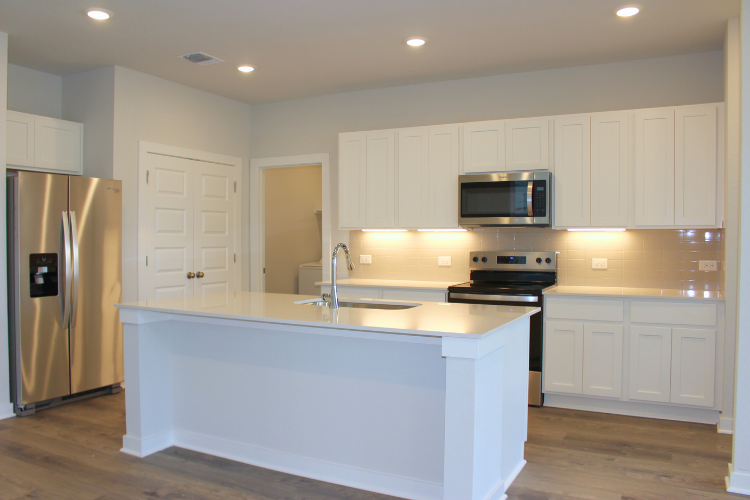 A kitchen with white cabinets.
