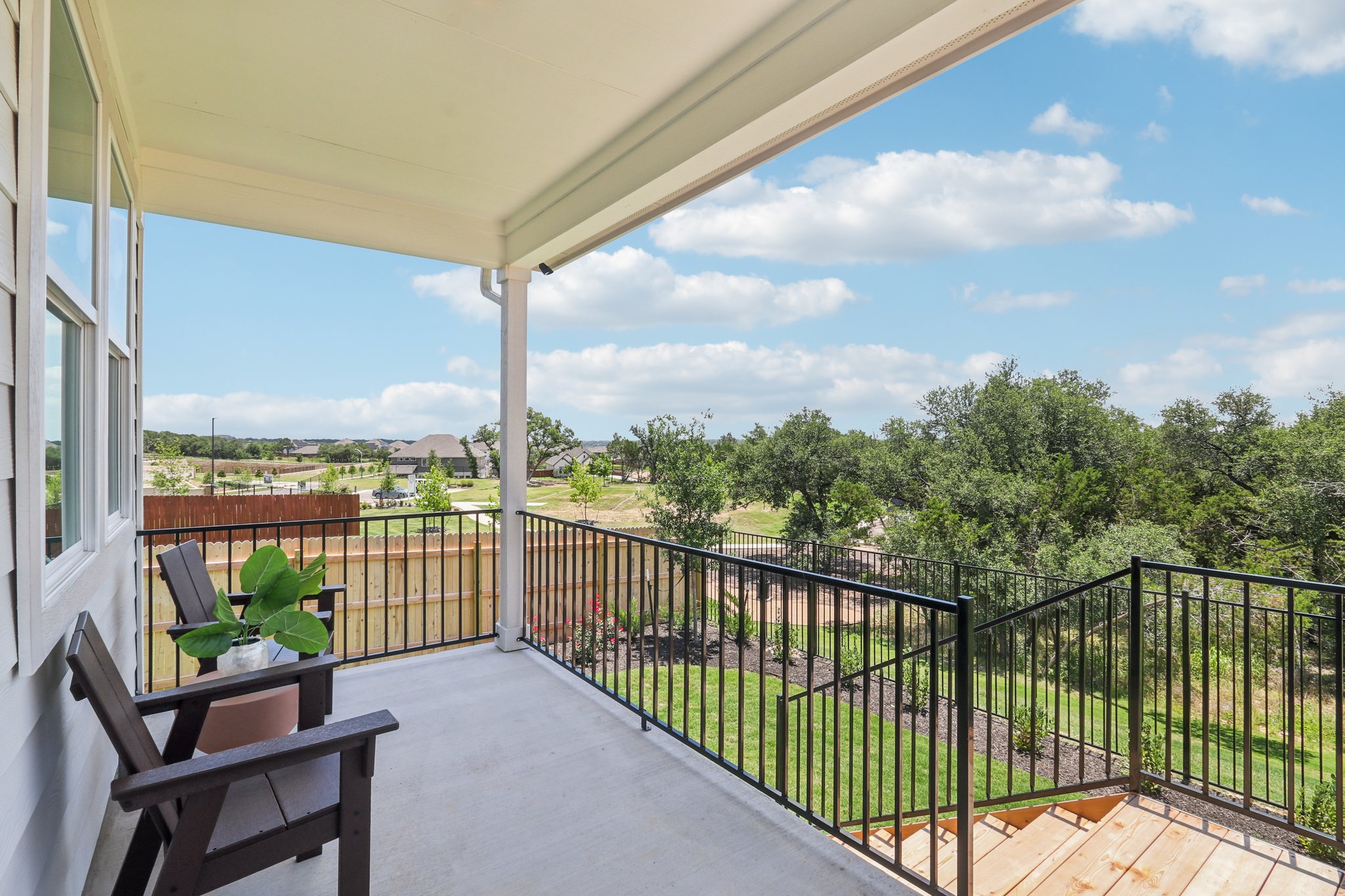 A deck with a railing and trees.