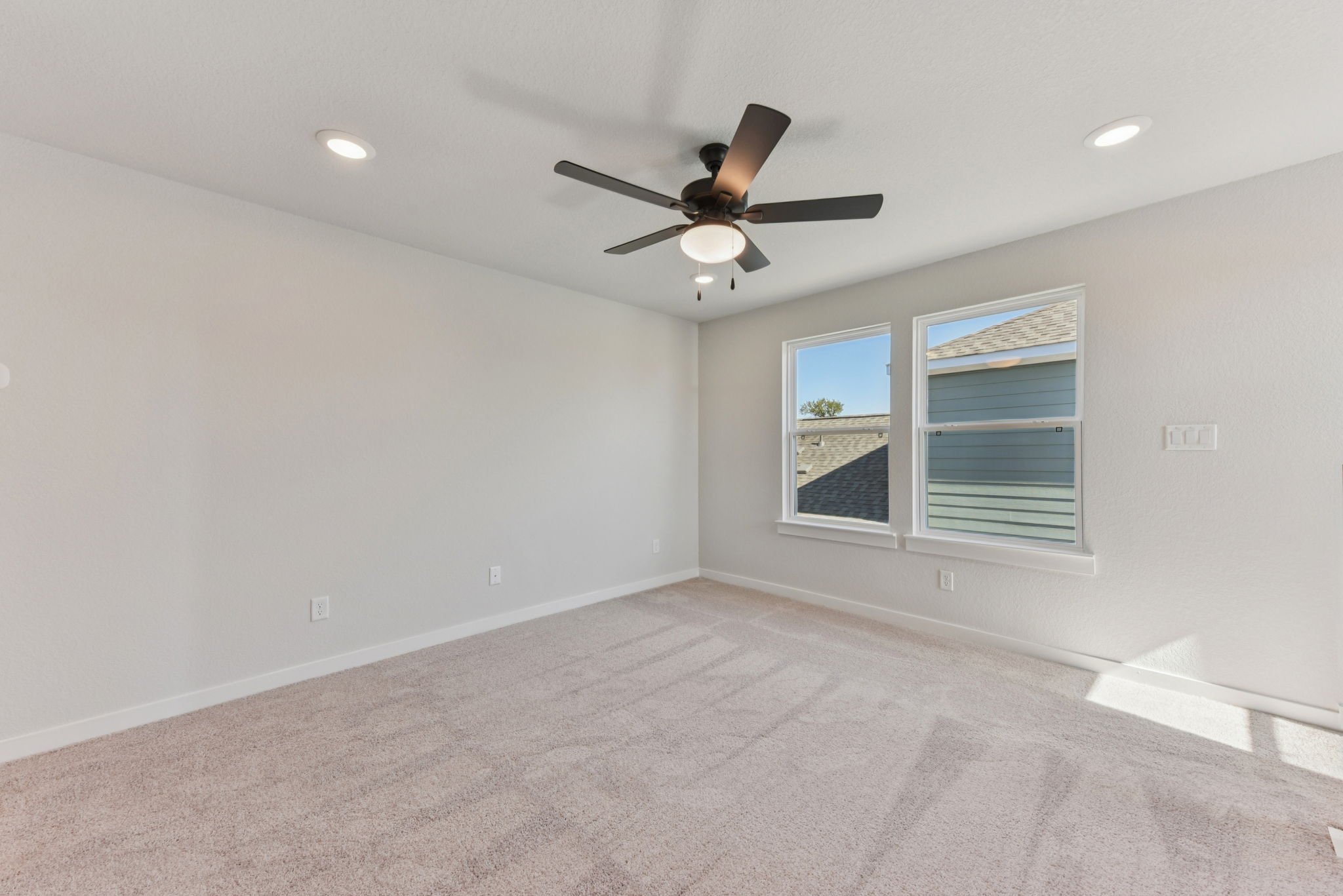 A room with a ceiling fan and a window.