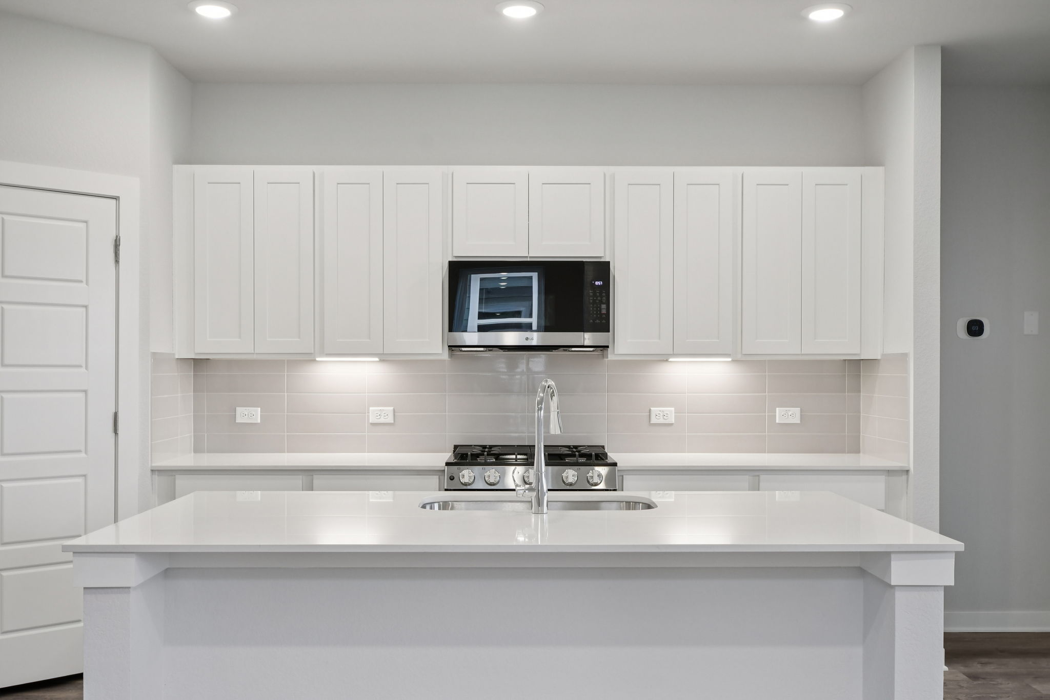 A kitchen with white cabinets.
