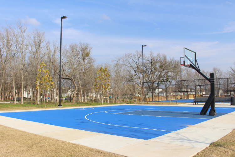 A basketball court with trees in the background.