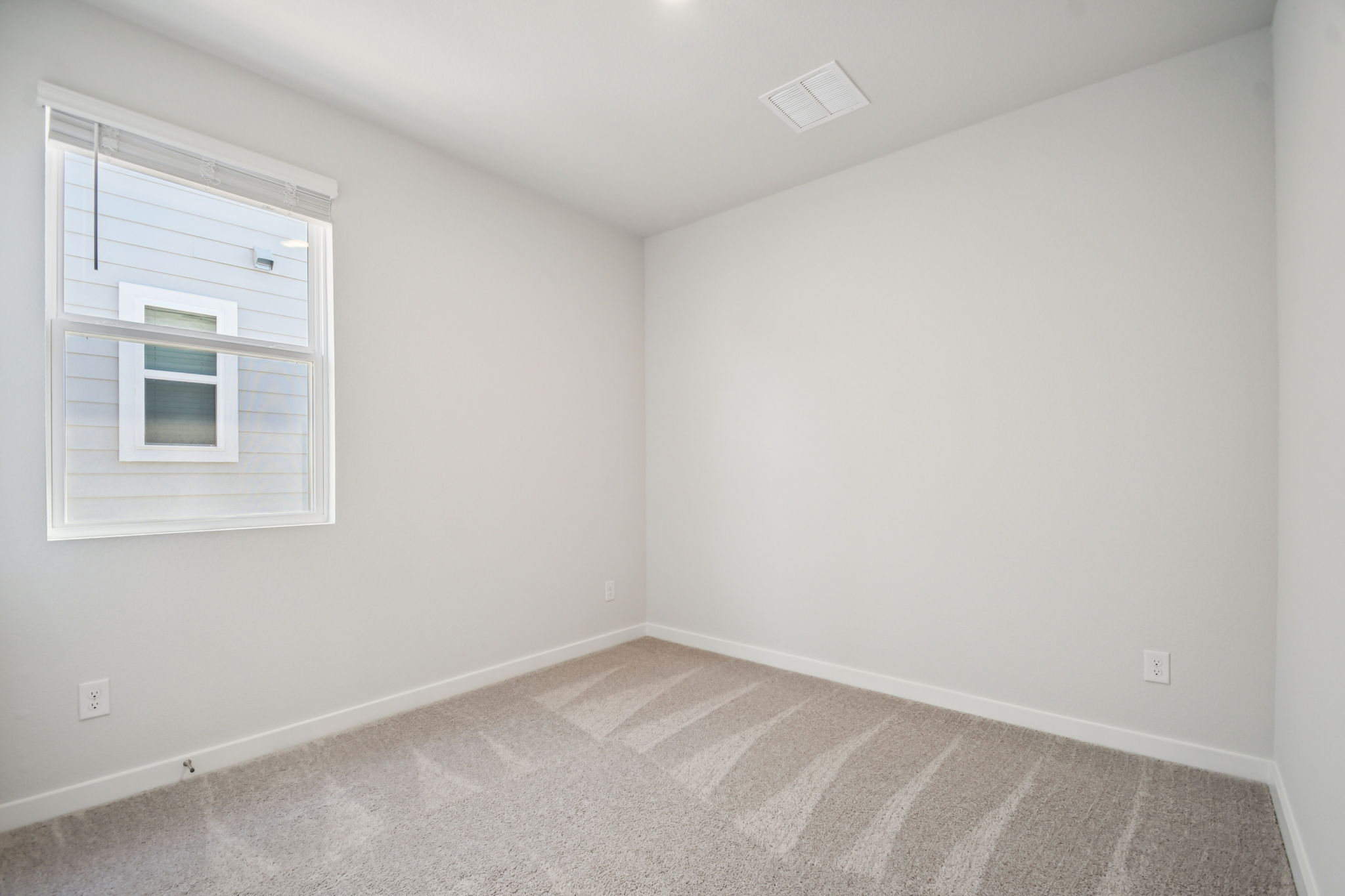 A room with a carpet and a window.
