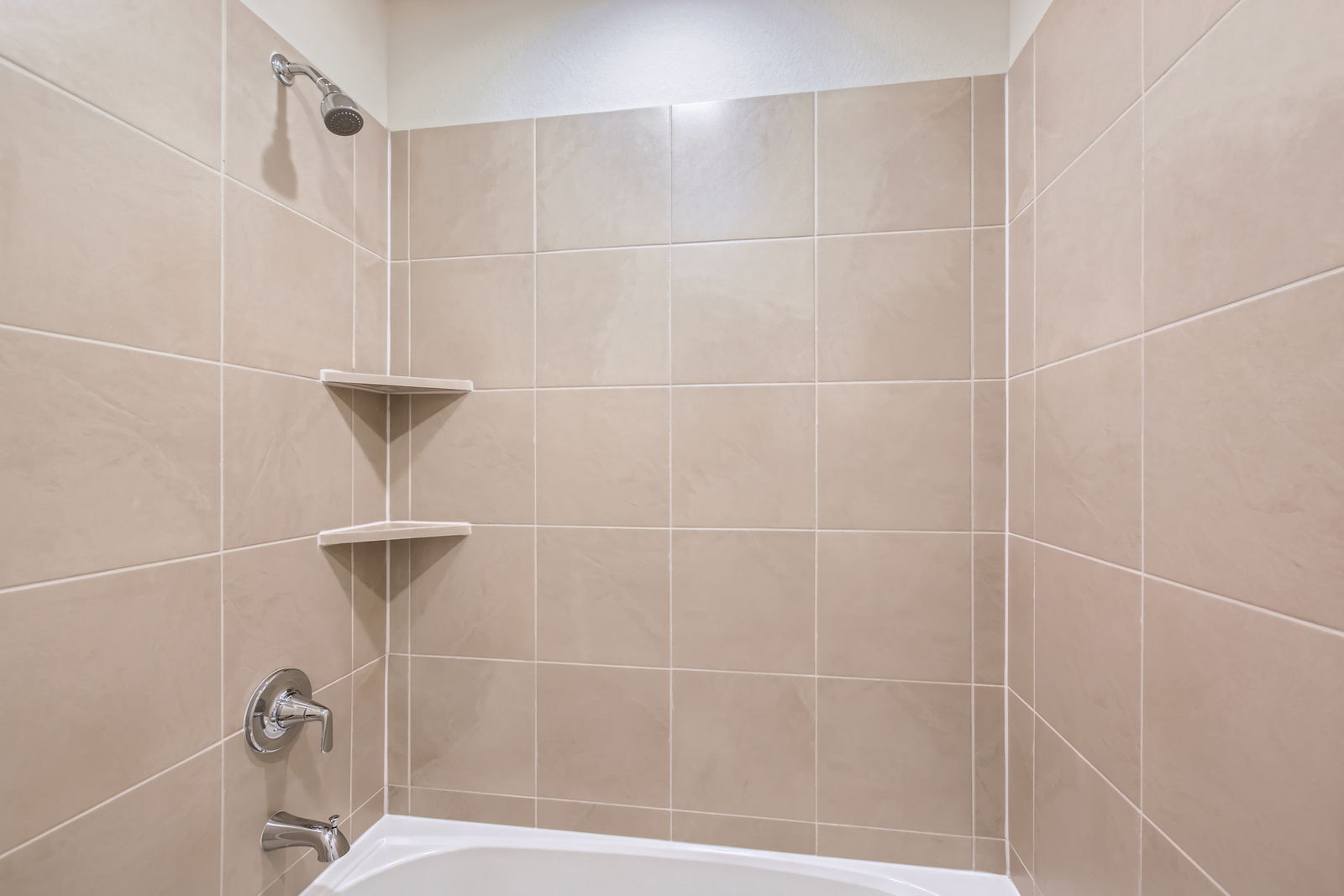 A bathroom with a bathtub and shelves.