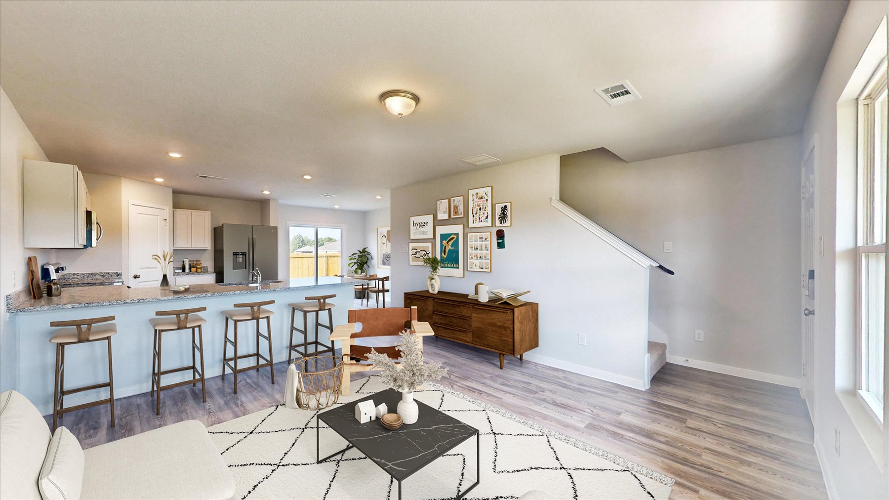 A kitchen with a bar and chairs.