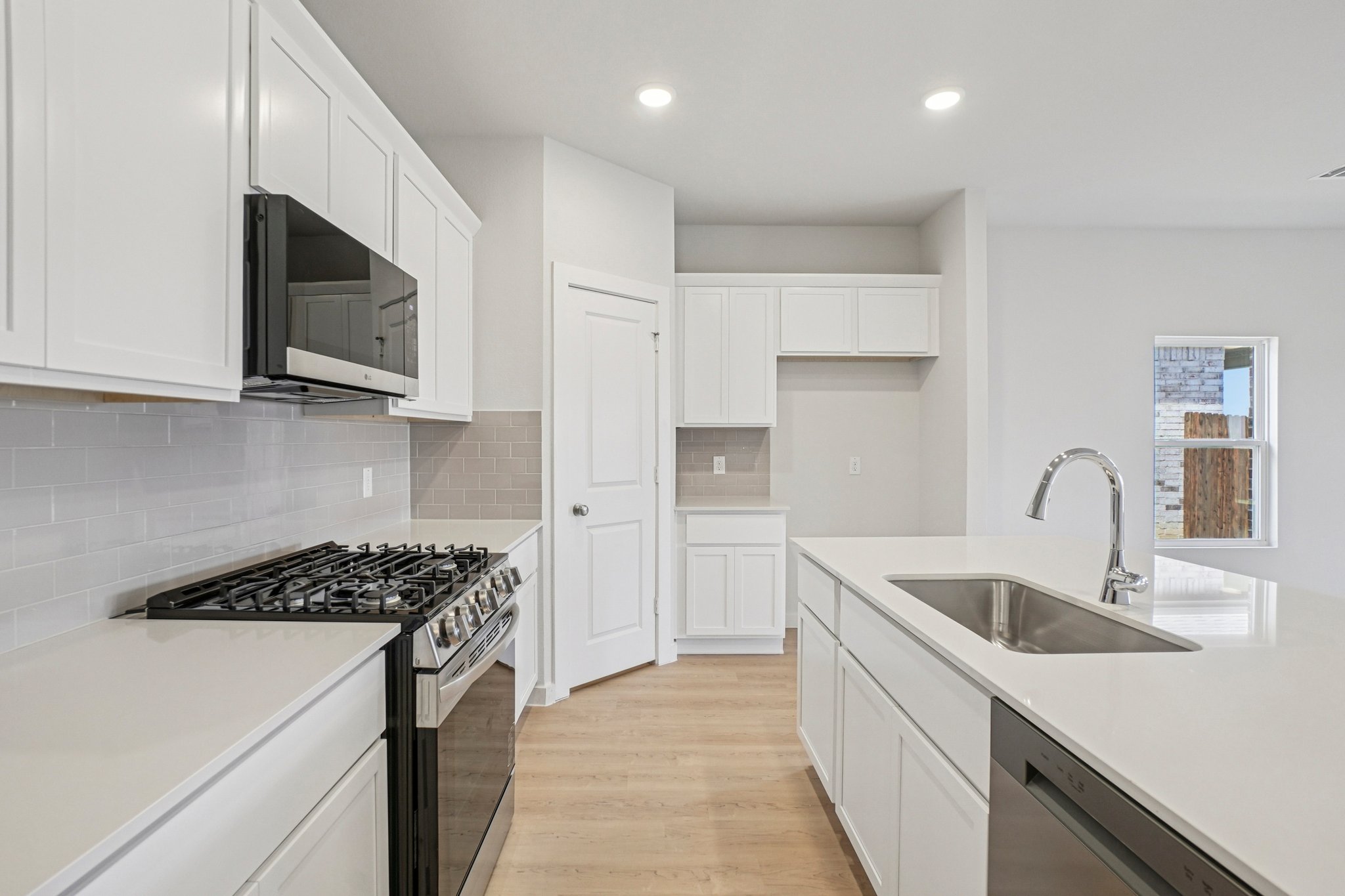 A kitchen with white cabinets.