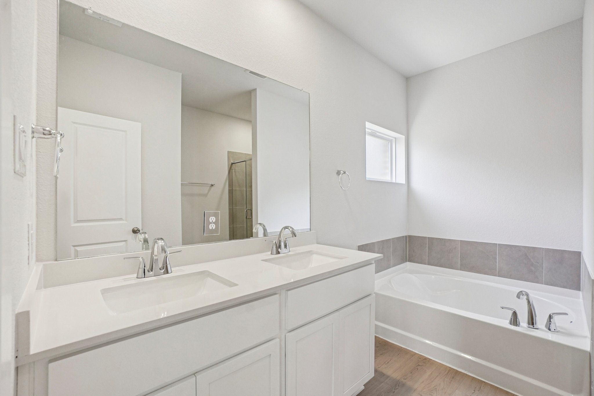 A bathroom with a tub sink and mirror.